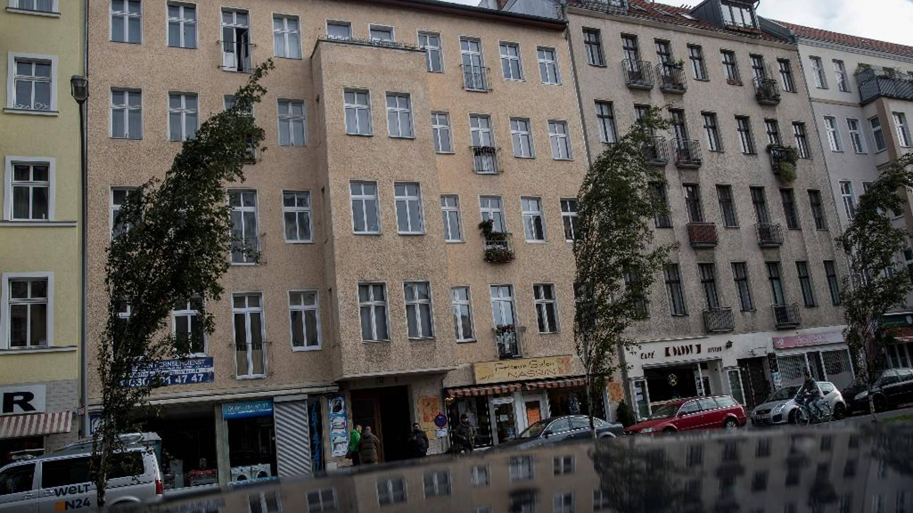 Cars park in front of the building where police arrested the terror suspect.