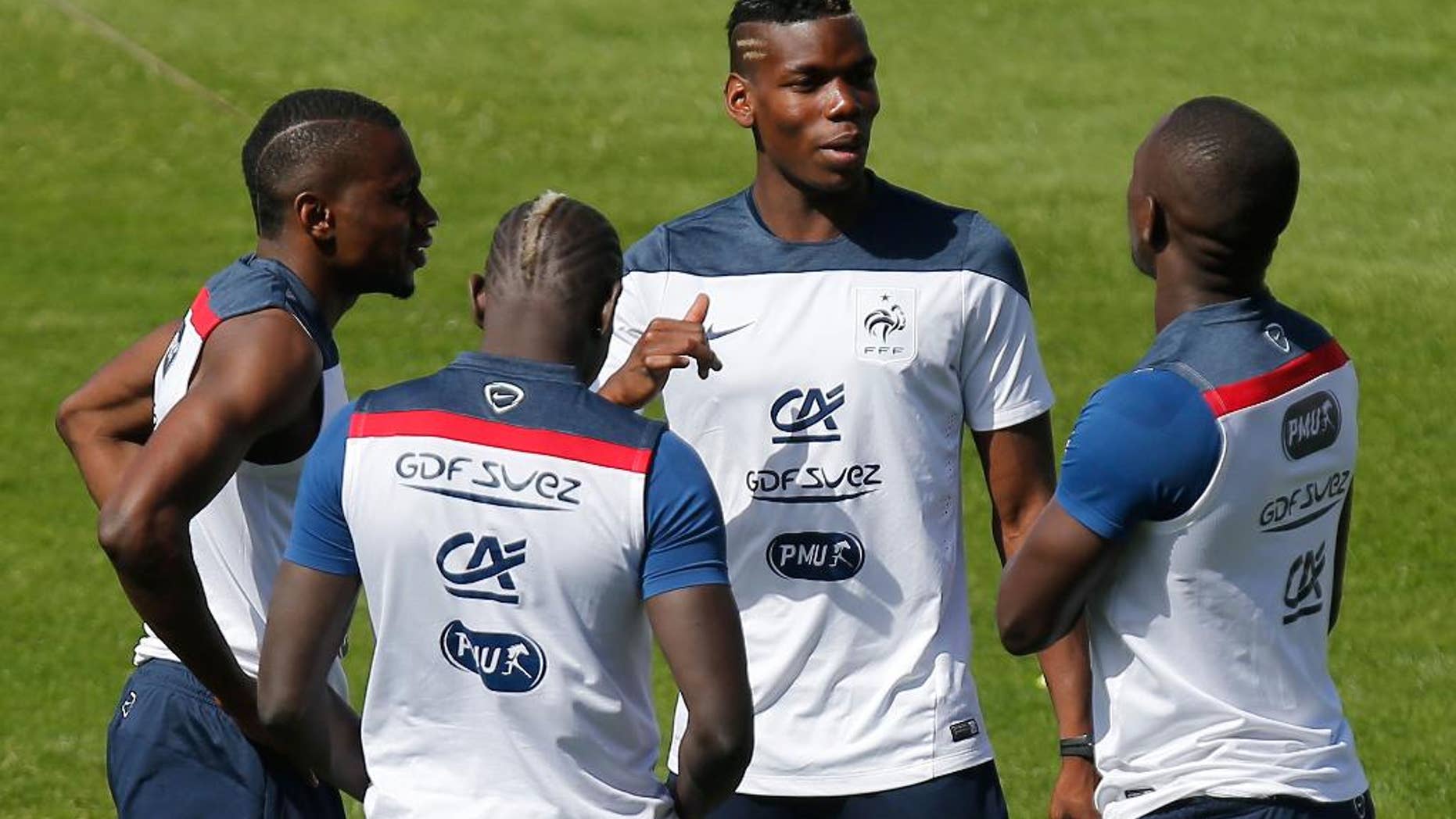 France's Blaise Matuidi, from left, Mamadou Sakho, Paul Pogba and Moussa Sissoko, stand on the pitch before the start of a training session at the Santa Cruz stadium, in Ribeirao Preto, Brazil, Wednesday, July 2, 2014. France will face Germany in their World Cup quarterfinal, Friday. (AP Photo/David Vincent)