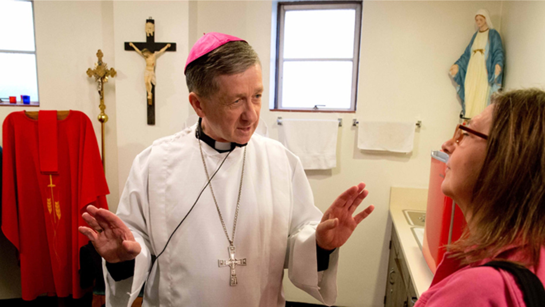 FILE - In this Sept. 21, 2014 file photo, Bishop Blase Cupich talks with choir member and friend Chris Johanek before mass at Saints Peter and Paul Church in Omaha, Neb. When appointed the new archbishop of Chicago, Blase Cupich argued that Pope Francis was sending a mere pastor and not a message. But Cupich has been sending Francis-like messages of his own as he prepares to officially assume leadership Tuesday, Nov. Nov. 18, 2014, of one of the largest and most high-profile archdioceses in the U.S. (AP Photo/Omaha World-Herald, James R. Burnett, File) MAGS OUT; ALL NEBRASKA LOCAL BROADCAST TELEVISION OUT