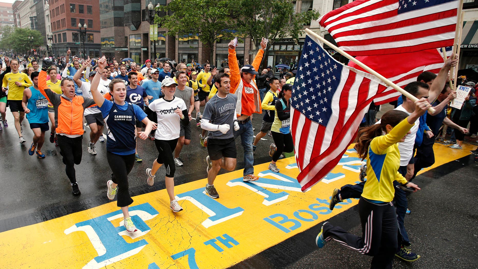 Runners who were unable to finish the Boston Marathon on April 15 because of the bombings cross the finish line on Boylston Street after the city allowed them to finish the last mile of the race in Boston, Saturday, May 25, 2013. (AP Photo/Winslow Townson)