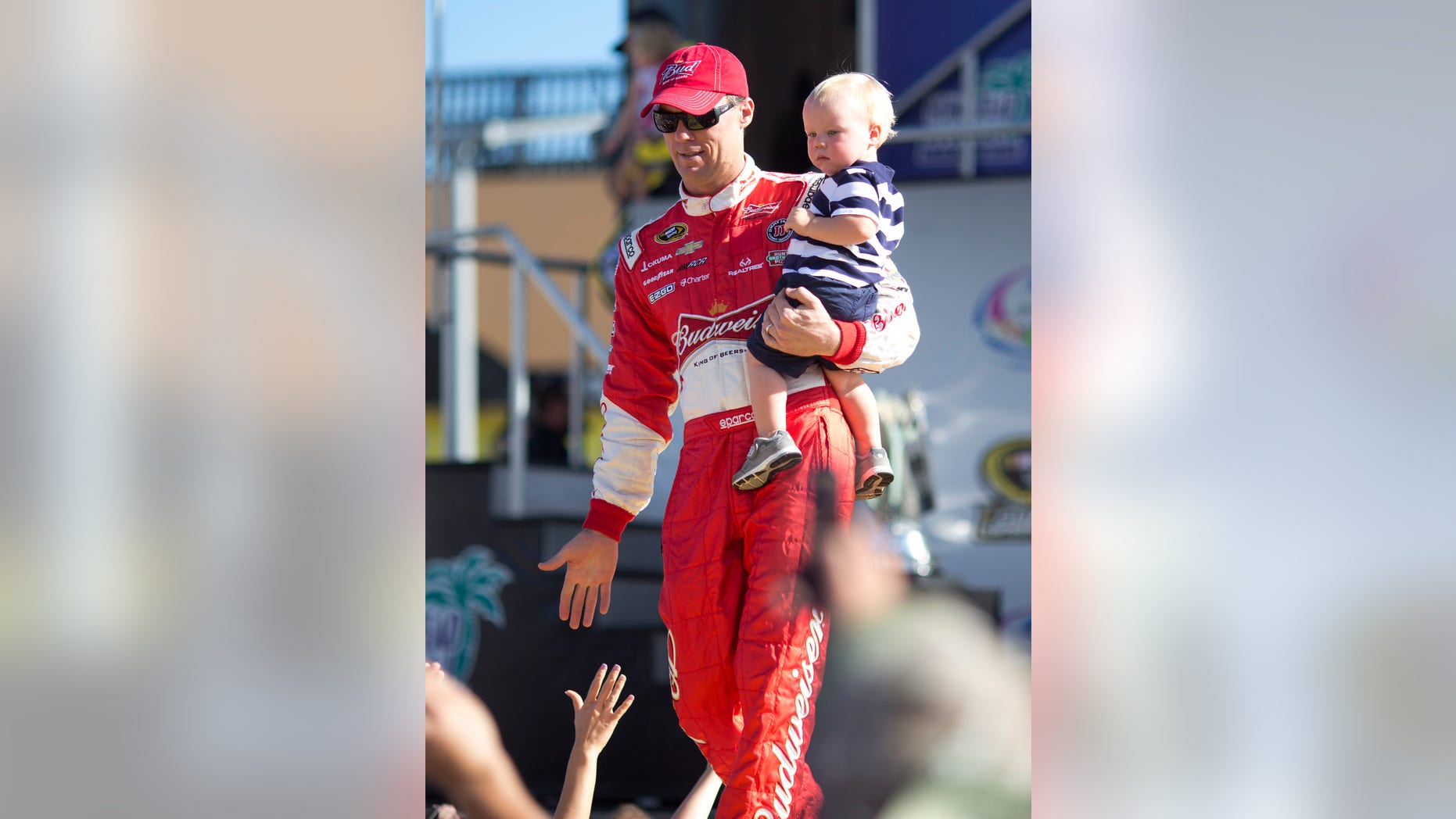 Kevin Harvick holds his with son, Keelan, as they greet fans during driver introductions before the NASCAR Sprint Cup Series auto race in Homestead, Fla., Sunday, Nov. 17, 2013. (AP Photo/J Pat Carter)