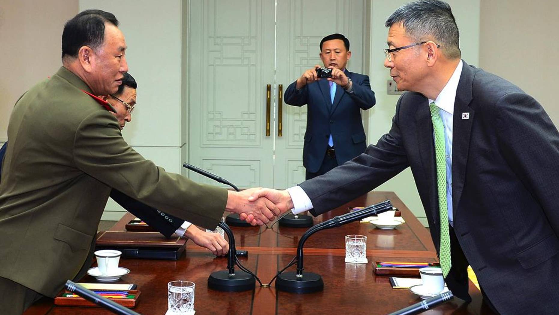 In this photo released by South Korean Defense Ministry, North Korean delegation chief Kim Yong Chol, left, shakes hands with his South Korean counterpart, Deputy Minister for National Defense Policy Ryu Je-seung during a meeting at the border village of Panmunjom, South Korea, Wednesday, Oct. 15, 2104. The first military talks between North and South Korea in more than three years ended with no agreement Wednesday, with the rivals failing to narrow their differences on how to ease animosities following two shooting incidents last week, South Korean officials said. (AP Photo/Defense Ministry)