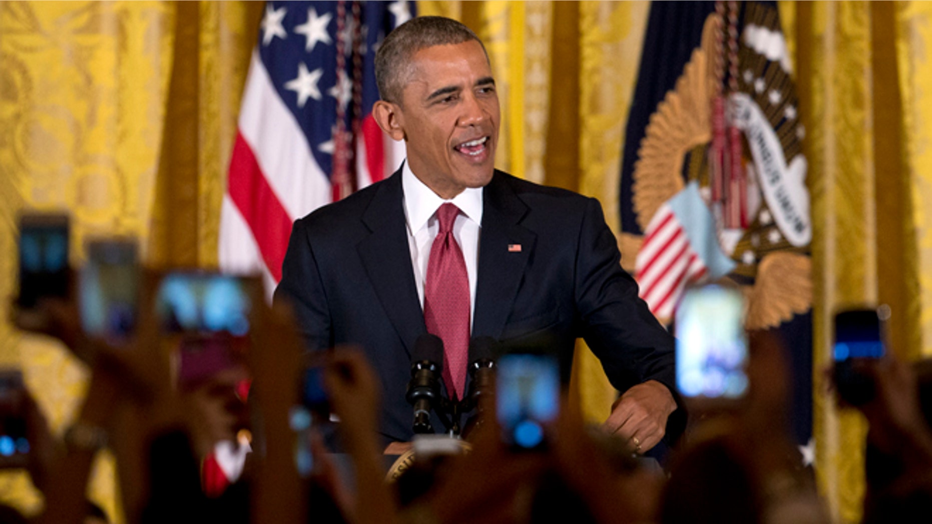 Audience members hold their cell phones high as President Barack Obama speaks during a Cinco de Mayo reception in the East Room of the White House in Washington, Tuesday, May 5, 2015. Obama says that when it comes to achieving a comprehensive overhaul of immigration laws progress is 'not always a straight line.' He says that despite his executive actions on immigration, Congress still needs to pass legislation to make more permanent changes. (AP Photo/Carolyn Kaster)