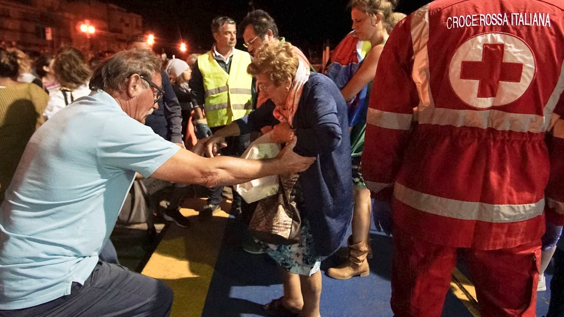 People disembark in the harbor of Pozzuoli, part of the Metropolitan City of Naples, southern Italy, early Tuesday, August 22, 2017, after an earthquake hit the island of Ischia, off the Neapolitan coast on Monday.