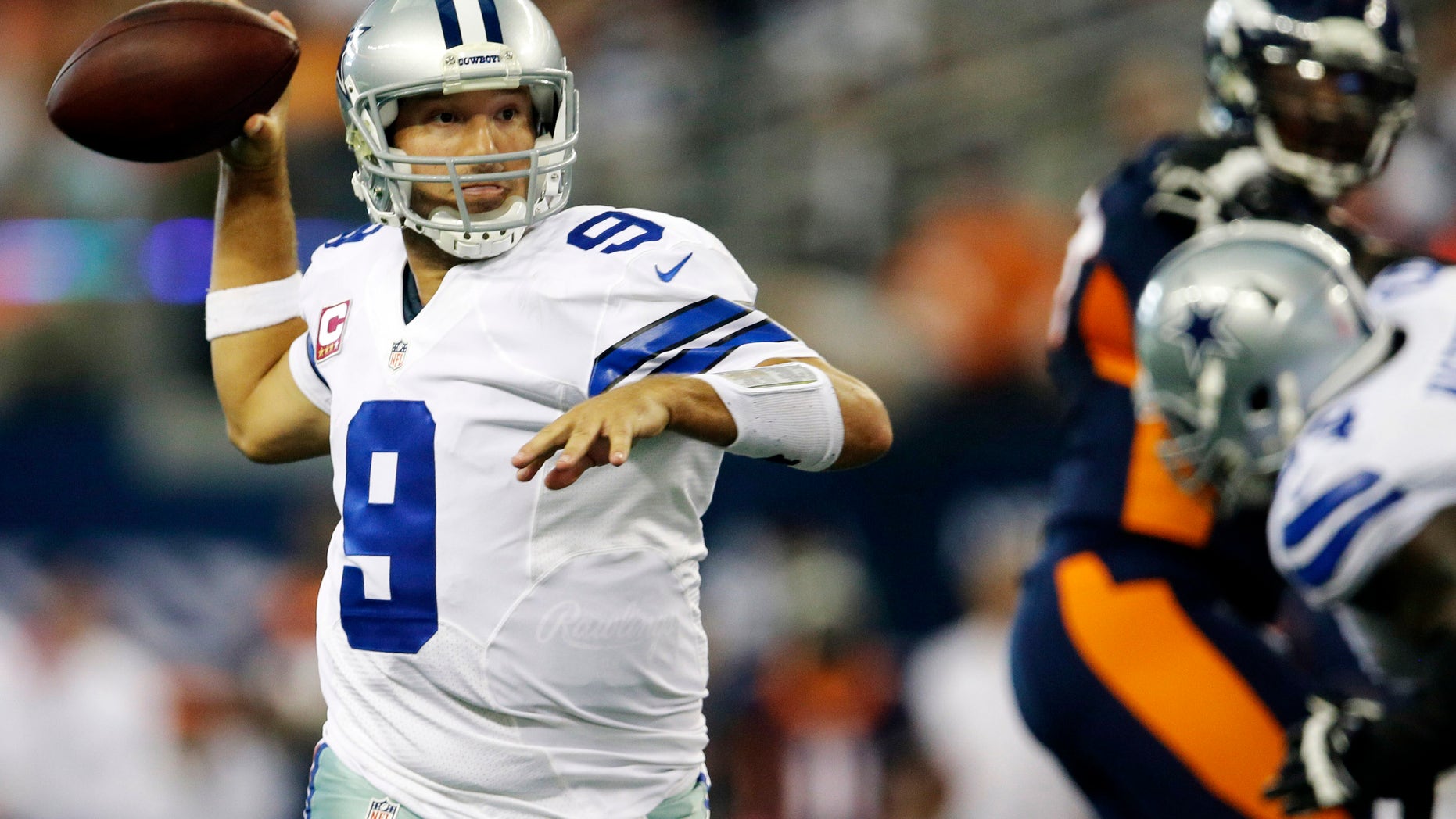 Dallas Cowboys quarterback Tony Romo rolls out to pass against the Denver Broncos during the fourth quarter of an NFL football game Sunday, Oct. 6, 2013, in Arlington, Texas. (AP Photo/Tony Gutierrez)