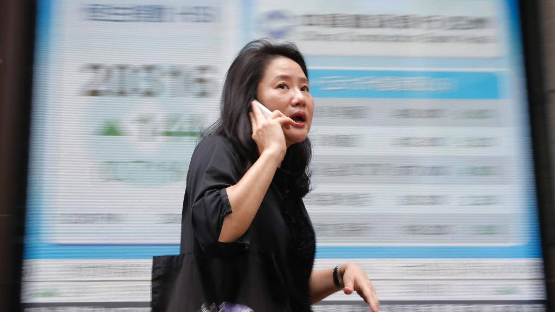 A woman walks passes a display of the Hang Seng Index at a bank in Hong Kong, Wednesday, June 29, 2016. Asian stock markets rallied on Wednesday following overnight gains on Wall Street and even bigger gains in Europe, as worries about uncertainty following Britain's EU referendum eased. (AP Photo/Kin Cheung)