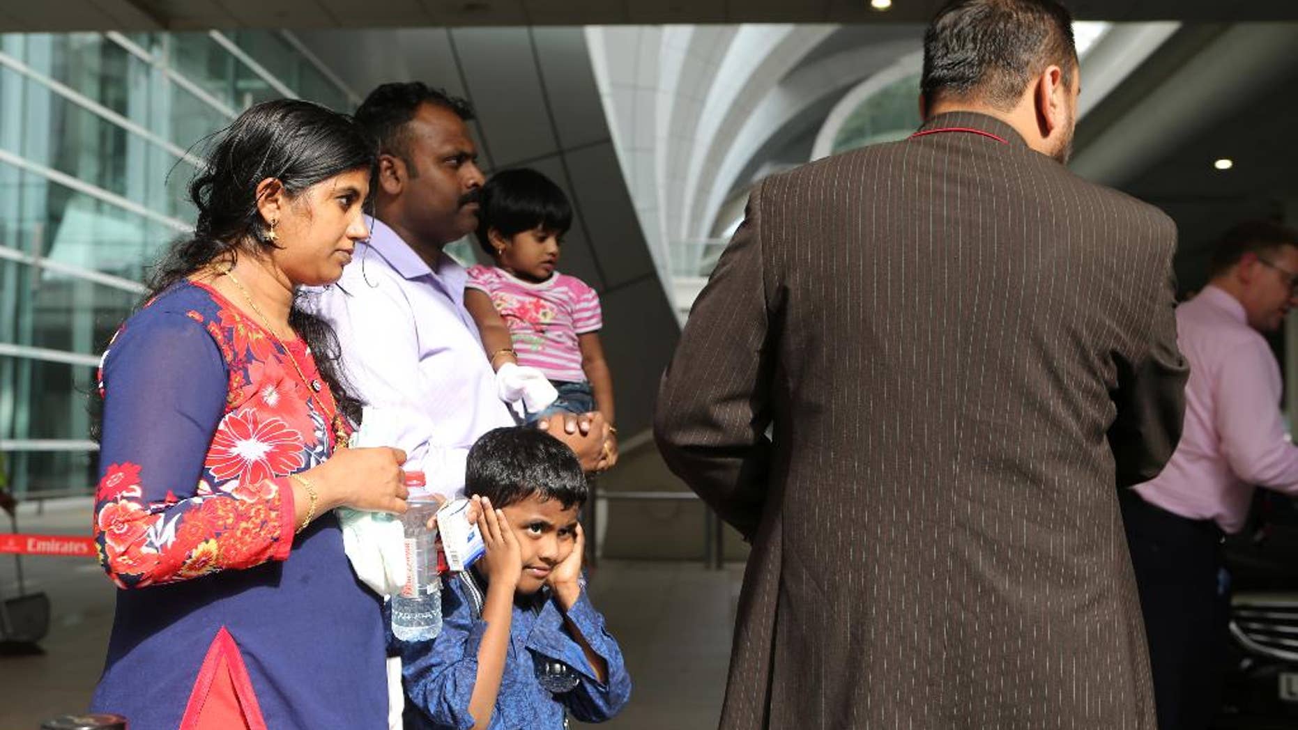 A family that were passengers onboard an Emirates jetliner that crash landed are helped to a taxi in Dubai, United Arab Emirates, on Wednesday, Aug. 3, 2016. n Emirates flight from India with 300 people on board crash landed at Dubai's main airport Wednesday, sending black smoke billowing into the air and halting all traffic at the Middle East's busiest airport. There were no fatalities and all the passengers were safely evacuated before the plane was engulfed in a fireball.(AP Photo/Jon Gambrell)