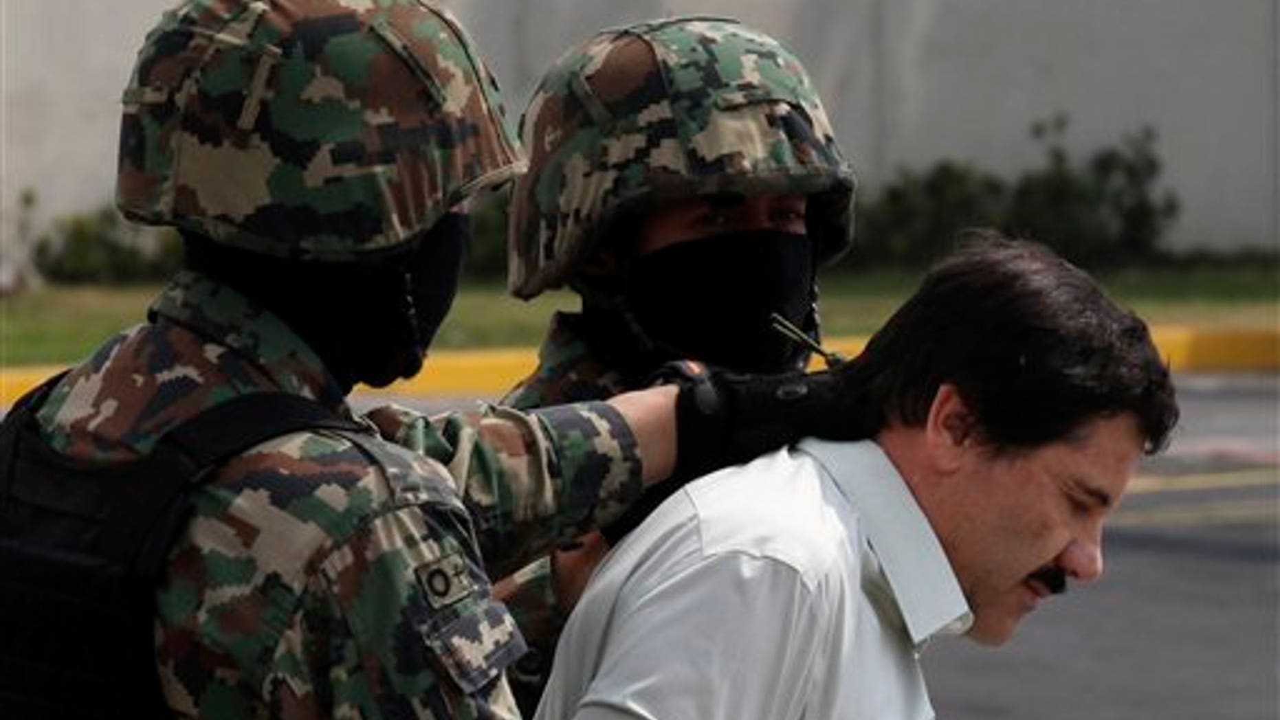 Feb. 22, 2014: Joaquin "El Chapo" Guzman, in handcuffs, is escorted to a helicopter by Mexican navy marines in Mexico City, Mexico.