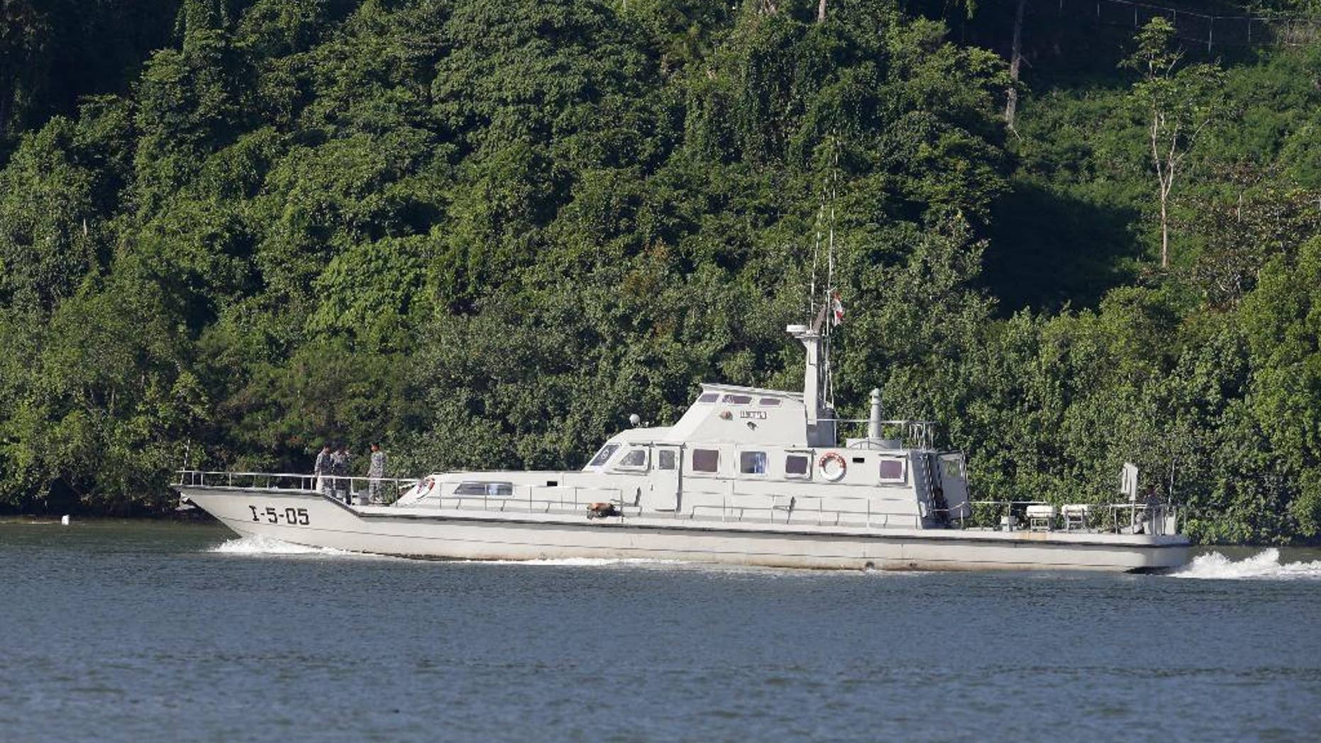 FILE - In this March 9, 2015 file photos, an Indonesian Navy boat carrying armed crew members patrol the waters near the prison island of Nusakambangan, background, as seen from Cilacap, Central Java, Indonesia as relatives of two Australian death row prisoners made their first visit to the island where the convicted drug traffickers are to be executed soon by firing squads. Indonesia may not execute 10 drug smugglers in the near future pending rulings on legal appeals filed by some of them. Vice President Jusuf Kalla said Wednesday, March 15 the government has to be careful and await the decisions by the Supreme Court. (AP Photo/Achmad Ibrahim, File)