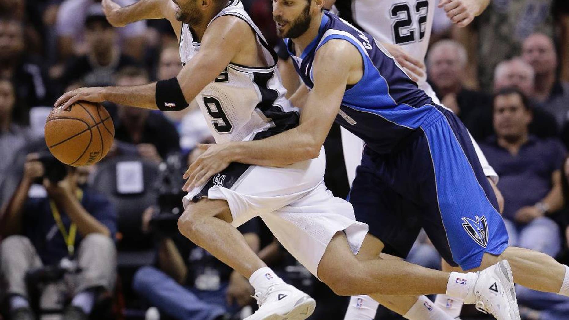 San Antonio Spurs' Tony Parker (9), of France, is fouled by Dallas Mavericks' Jose Calderon (8), of Spain, during the second half of Game 5 of the opening-round NBA basketball playoff series on Wednesday, April 30, 2014, in San Antonio. San Antonio won 109-103. (AP Photo/Eric Gay)
