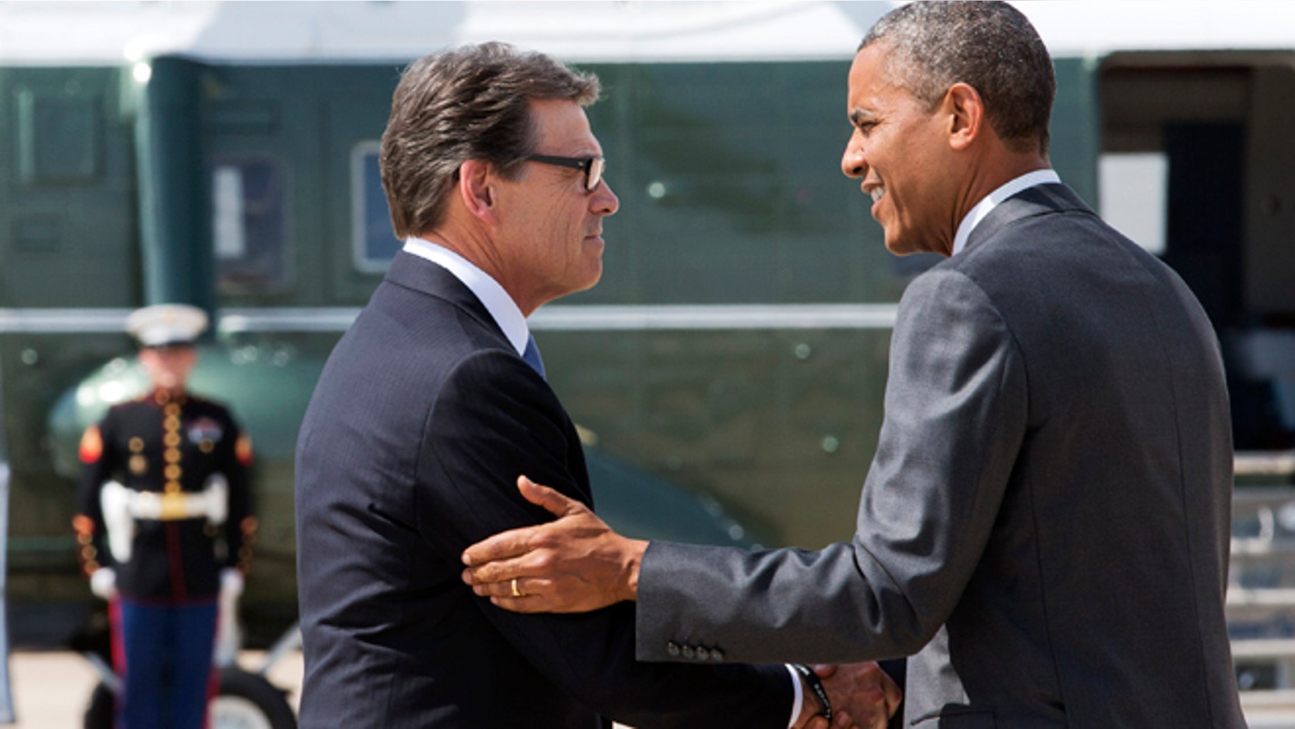 President Barack Obama, right, and Texas Gov. Rick Perry shake hands as Obama arrives in Dallas where they will attend a meeting about the border and immigration together, Wednesday, July 9, 2014. (AP Photo/Jacquelyn Martin)