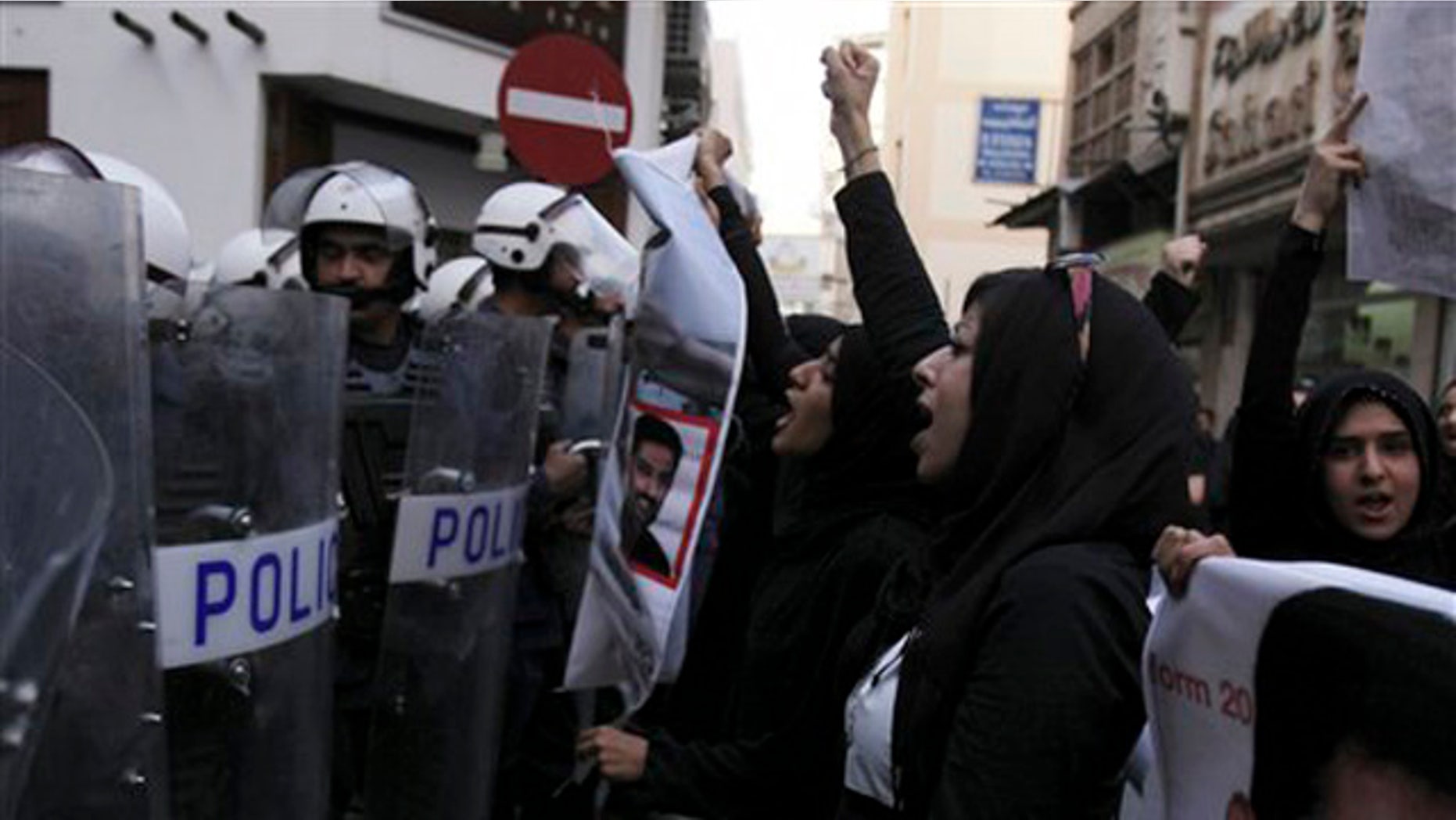 April 18, 2012: Bahraini anti-government activist Zainab al-Khawaja, second right, gestures and chants slogans in front of riot police during a protest in downtown Manama, Bahrain.
