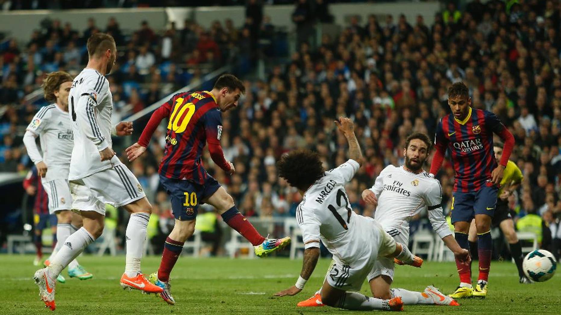 Barcelona's Lionel Messi from Argentina, centre left, scores his goal during a Spanish La Liga soccer match between Real Madrid and FC Barcelona at the Santiago Bernabeu stadium in Madrid, Spain, Sunday, March 23, 2014. (AP Photo/Andres Kudacki)