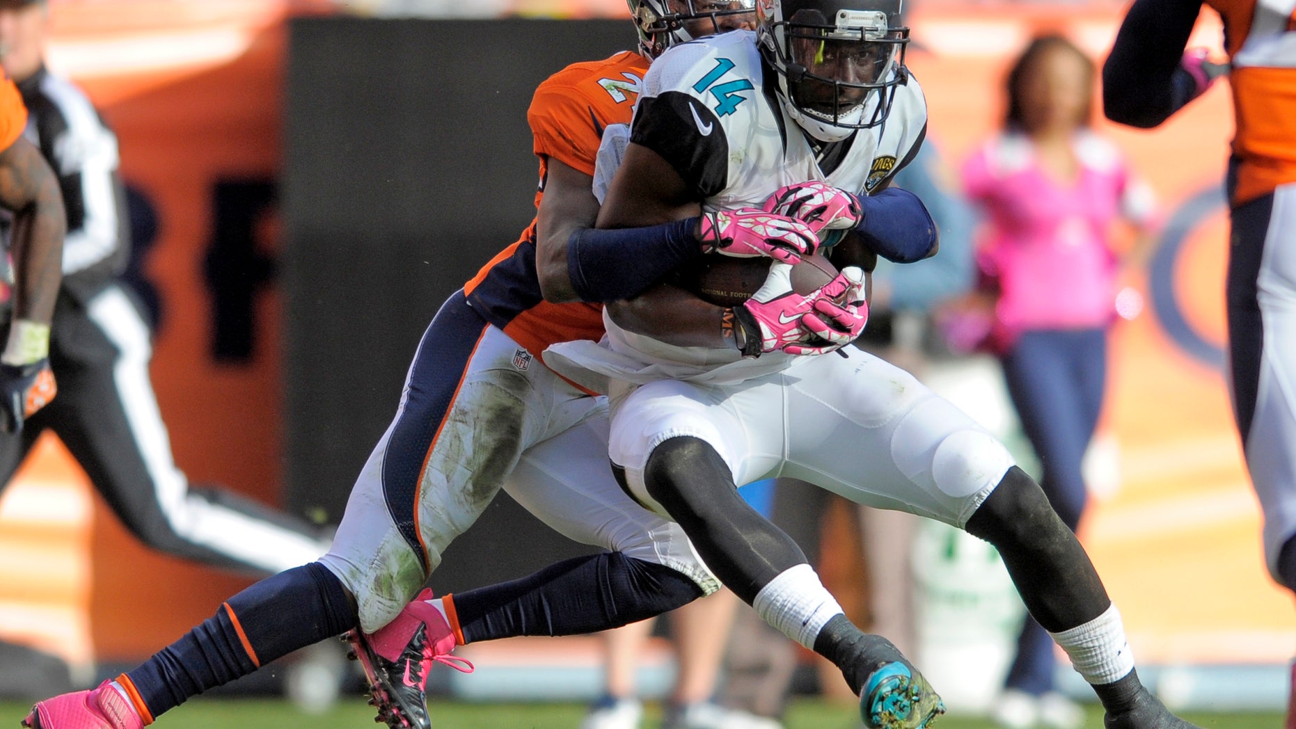 FILE- In this Oct. 13, 2013, file photo, Jacksonville Jaguars wide receiver Justin Blackmon (14) is tackled by Denver Broncos cornerback Champ Bailey (24) during an NFL football game in Denver. The second-year receiver has caught 19 passes for 326 yards and a touchdown in two games since returning from a four-game suspension. He could be the top target again Sunday since Cecil Shorts III is dealing with a shoulder injury. (AP Photo/Jack Dempsey, File)