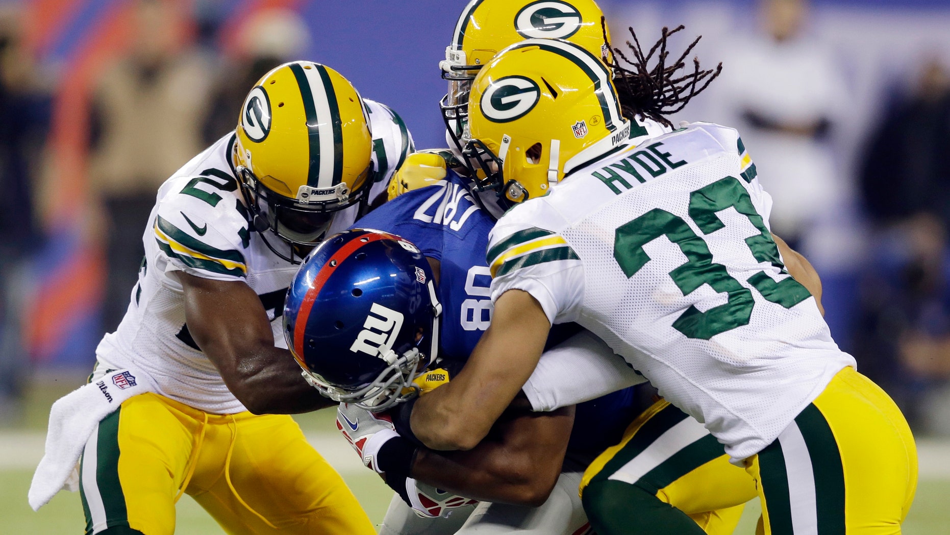 New York Giants wide receiver Victor Cruz (80) is tackled by Micah Hyde (33), Davon House, and Jarrett Bush, left, during the first half of an NFL football game Sunday, Nov. 17, 2013, in East Rutherford, N.J. (AP Photo/Seth Wenig)