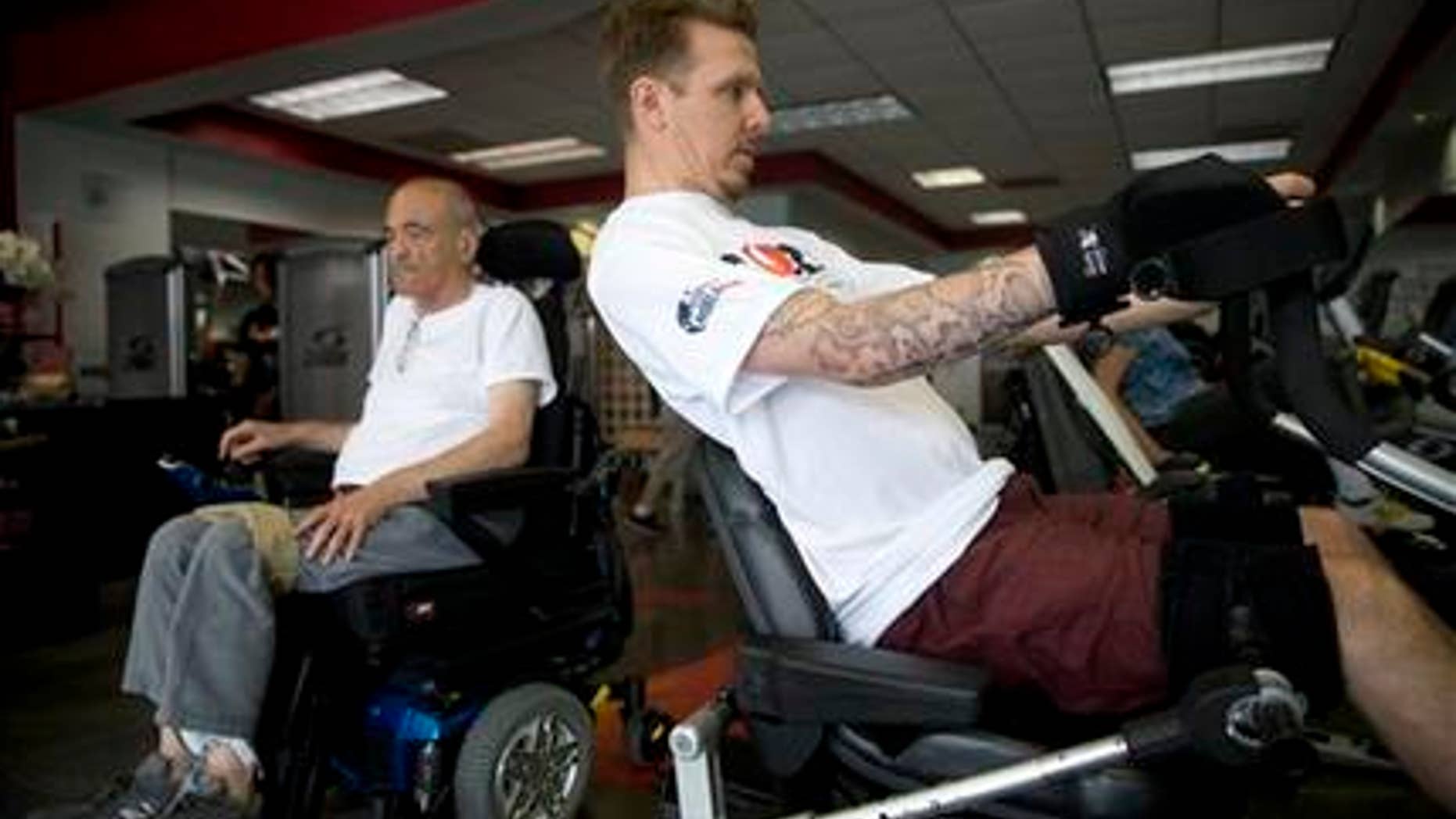 May 5, 2015: In this photo, Aaron Baker, right, a former motocross racer who was paralyzed from the neck down in a crash while practicing on a motocross track in 1999, exercises at the Center of Restorative Exercise in the Northridge section of Los Angeles.