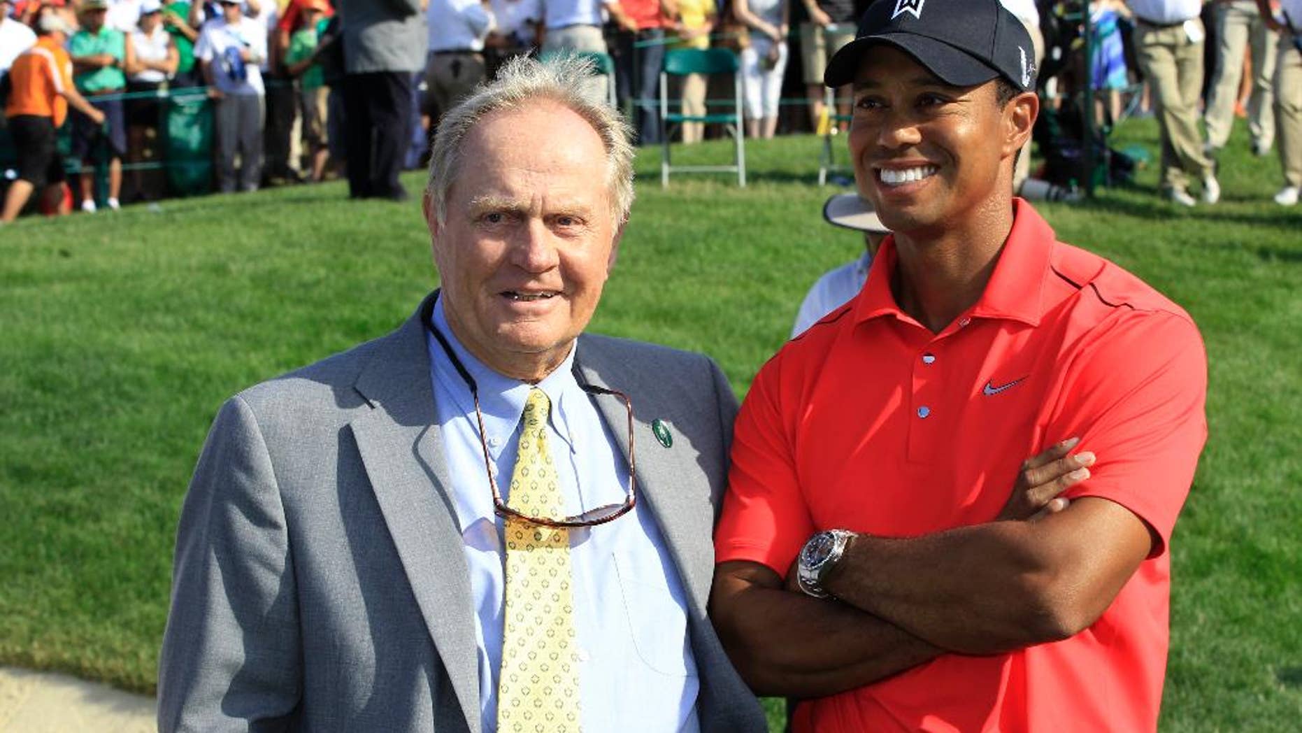 File-This June 3, 2012, file photo shows Jack Nicklaus, left, and Tiger Woods talking after Woods won the Memorial golf tournament at the Muirfield Village Golf Club in Dublin, Ohio. Nicklaus says he was "painting a picture" when he suggested after a practice round with Tiger Woods at the 1996 Masters that Woods had the game to win at least 10 green jackets. He referred to Woods as a "puzzle" on Sunday, Feb. 26, 2017, at the Honda Classic. (AP Photo/Tony Dejak, File)