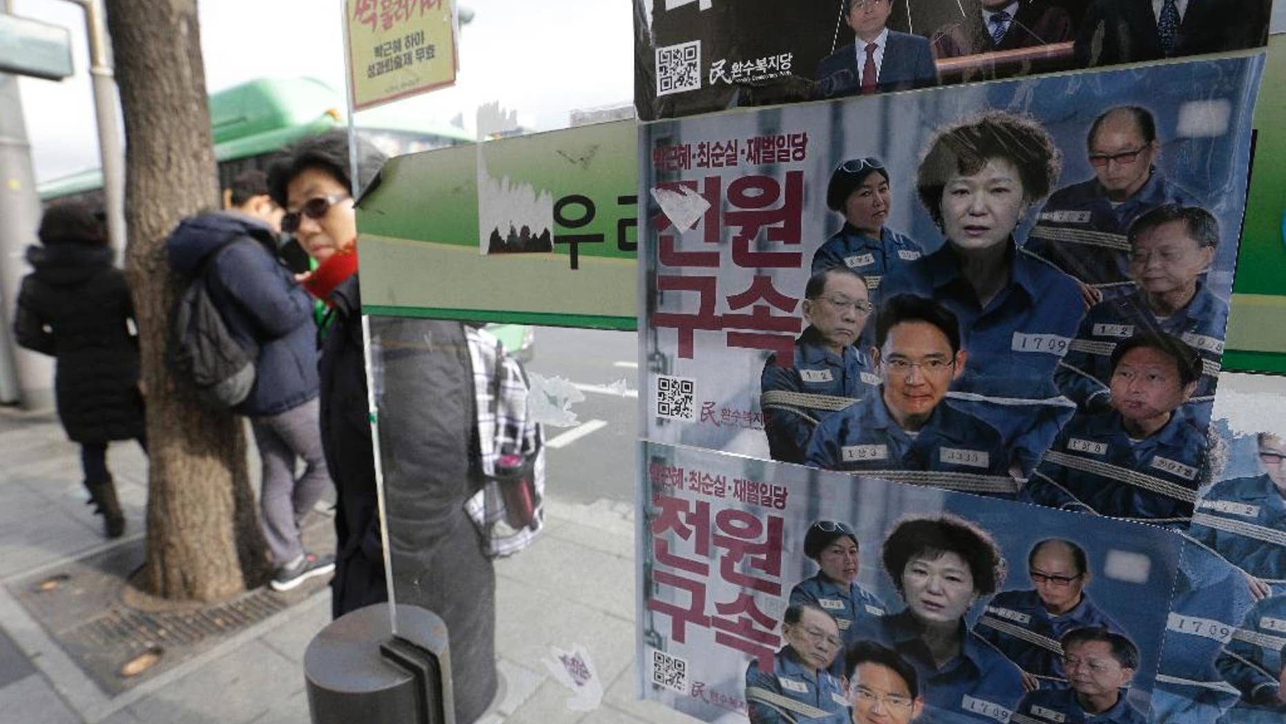 FILE-In this Dec. 19, 2016, file photo, posters showing portraits of impeached South Korea's President Park Geun-hye, center, her aides and business men are displayed at a bus station in Seoul, South Korea. Prosecutors will not be allowed to search South Korea's presidential compound as part of their investigation of the massive corruption scandal that toppled Park from power, the president's office said Thursday, Feb. 2, 2017. The letter read "Arrest." (AP Photo/Ahn Young-joon, File)