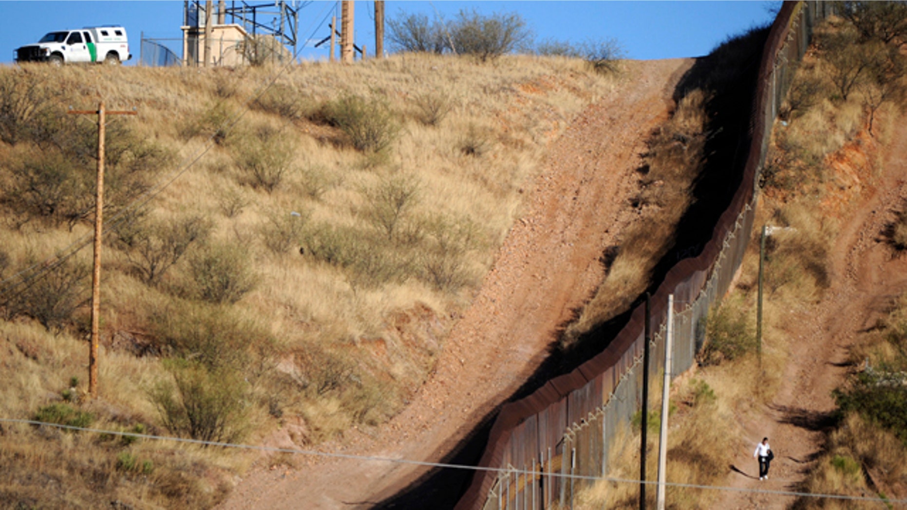 FILE 2011: A woman walks near the border fence between Mexico and the United States in Nogales.