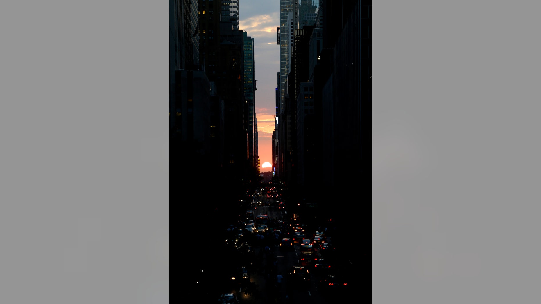 The sun sets through the middle of buildings on 42nd Street in New York's Manhattan borough, during a phenomenon known as Manhattanhenge, Wednesday, July 11, 2012. Manhattanhenge, sometimes referred to as the Manhattan Solstice, happens when the setting sun aligns with the east-to-west streets of the main street grid. The term references Stonehenge, at which the sun aligns with the stones on the solstices in England. (AP Photo/Julio Cortez)
