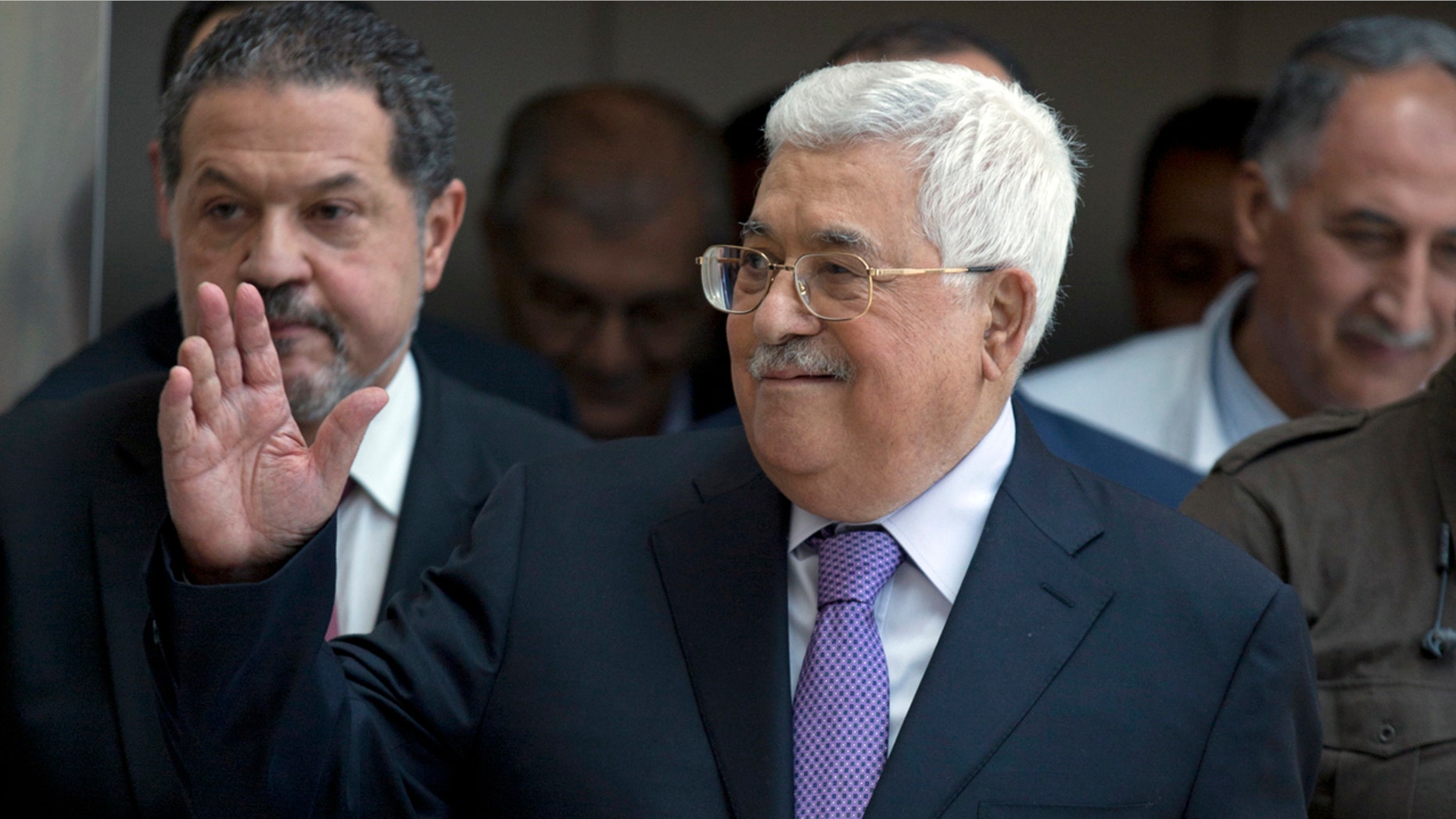 Palestinian President Mahmoud Abbas waves to supporters as he leaves the hospital in the West Bank city of Ramallah, Monday, May 28, 2018.