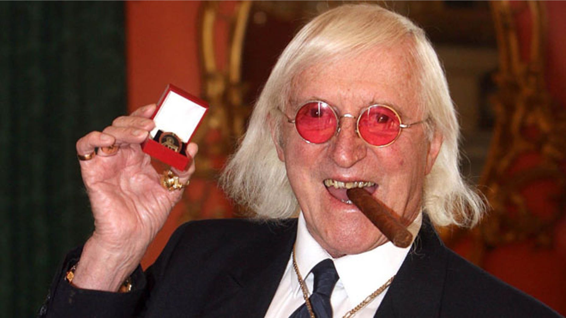 March 25, 2008: This file photo shows Jimmy Savile showing a medal in London.