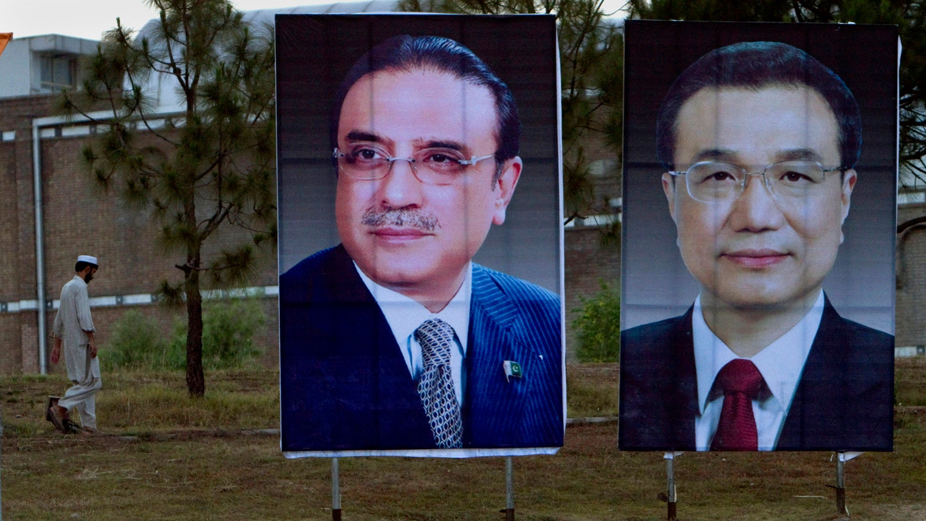 A man walks next to huge portraits of Chinese Premier Li Keqiang, right, and Pakistani President Asif Ali Zardari, left, displayed near the presidency in Islamabad, Pakistan. Keqiang will arrive in Islamabad on May 22 on a two day official visit to hold talks with Pakistani leadership to discuss international, regional issues and enhance co-operation in bilateral ties. (AP Photo/Anjum Naveed)
