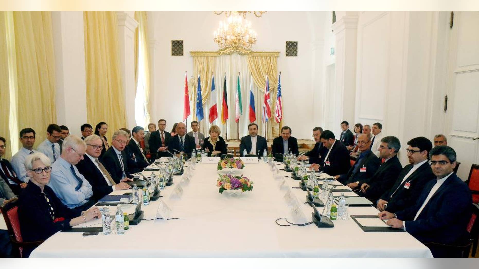 FILE - In this Friday, June 12, 2015 file photo delegates sit around a table prior to a bilateral meeting as part of the closed-door nuclear talks with Iran at a hotel in Vienna, Austria. Iran and six powers are still apart on all main elements of a nuclear deal with less than two weeks to go to their June 30 target date and will likely have to extend their negotiations, two diplomats tell The Associated Press. (AP Photo/Ronald Zak, File)