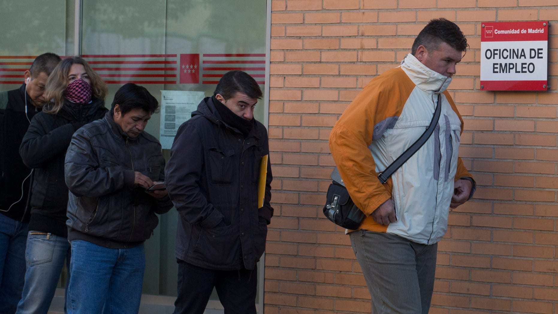 People queue to enter an unemployment registry office in Madrid, Spain, Tuesday, Dec. 3, 2013. Official figures show the number of people registered as unemployed in Spain fell by a little under 2,500 in November, the first drop during the month since the current system was introduced 1997. The decline provided further evidence that the Spanish economy might be picking up after more than two years of recession, which only ended in the third quarter. Still, Spain is still suffering from mass unemployment, with around 4.8 million people out of work. That represents around 26 percent of its total workforce. Only Greece has a higher unemployment rate in the 17-country eurozone. (AP Photo/Paul White)