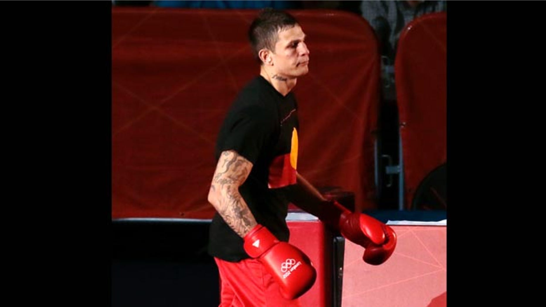 July 30, 2012: Australia's Damien Hooper wears a T-shirt bearing the Aboriginal flag as he makes his way to the ring to fight United States' Marcus Browne at the 2012 Summer Olympics.
