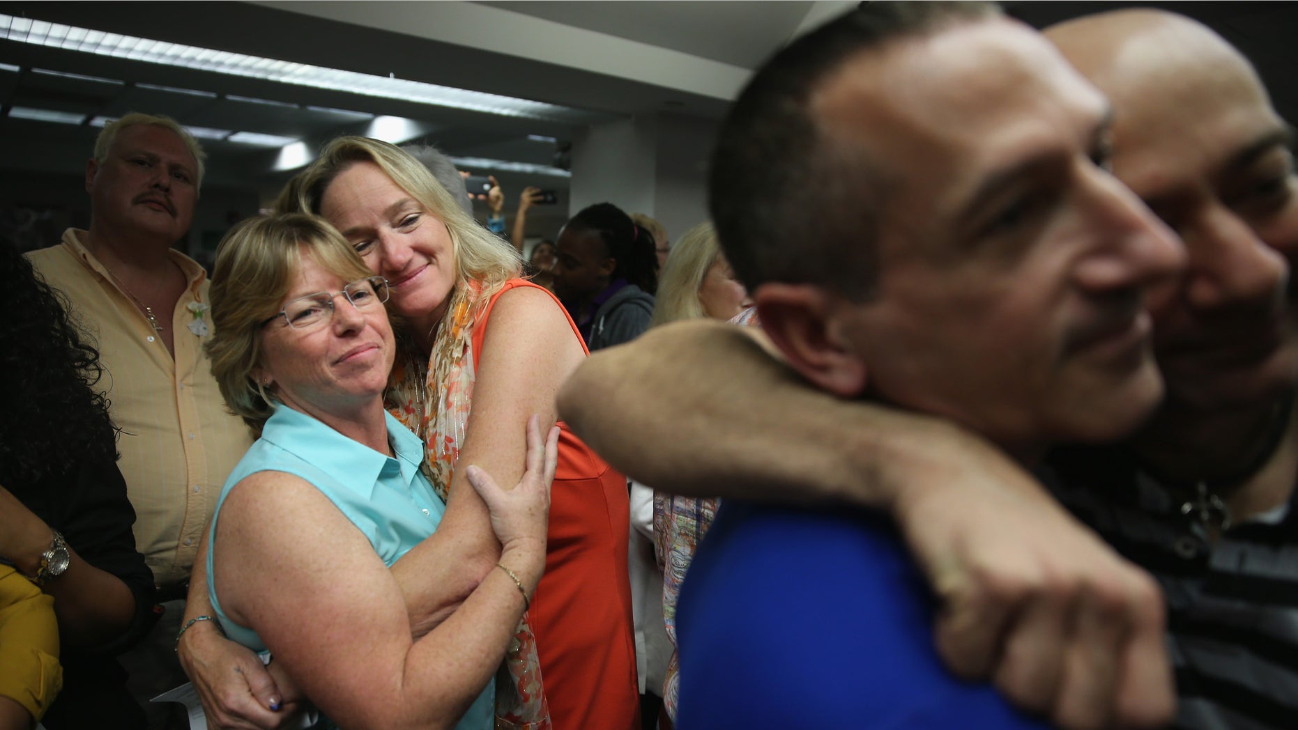 FORT LAUDERDALE, FL - JANUARY 06: Couples embrace as they attend a wedding ceremony at the Broward County Courthouse on January 6, 2015 in Fort Lauderdale, Florida. Gay marriage is now legal statewide after the courts ruled that the ban on gay marriage is unconstitutional and the Supreme Court declined to intervene. (Photo by Joe Raedle/Getty Images)