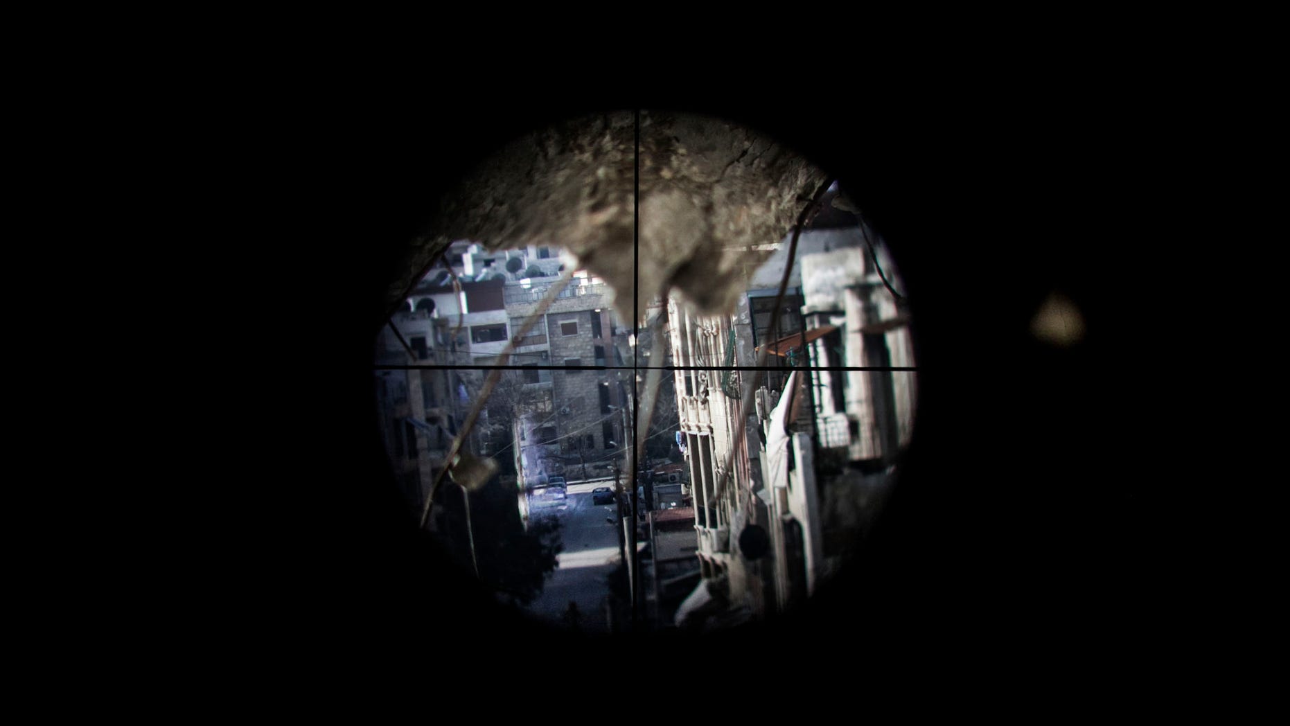 Una calle controlada por fuerzas del gobierno vista a través de la mirilla de un francotirador en el vecindario de Saif al-Dawlah, en Aleppo, Siria, el domingo 13 de enero de 2013. (Foto AP/Andoni Lubaki)