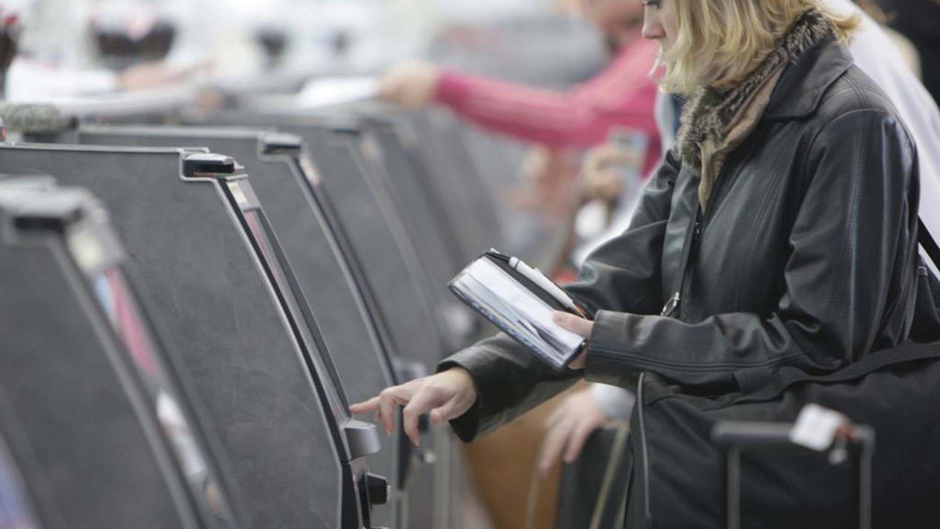 FILE - In this Oct. 27, 2009 file photo, a traveler checks in for her flight at an American Airlines ticket kiosk at Lambert St. Louis International Airport in St. Louis. Thieves with stolen usernames and passwords have broken into customer accounts at American and United airlines and in some cases booked free trips, the airlines said Monday, Jan. 12, 2015. (AP Photo/Jeff Roberson, File)