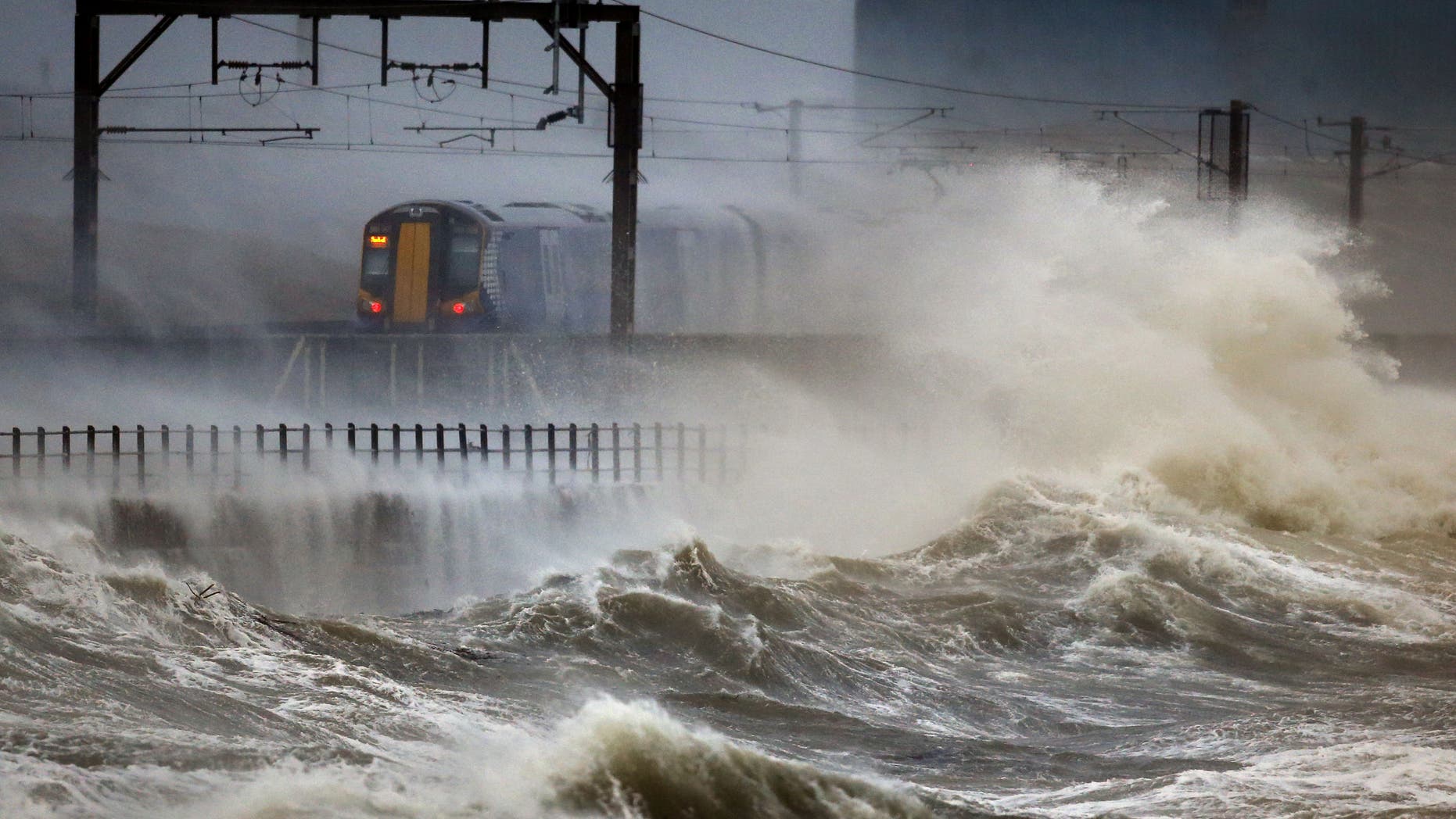 A train passes along the coast at Saltcoats in Scotland, Friday, Jan. 2014, as Britain is braced for the worst as a combination of high tides, heavy rains and strong winds are expected to bring yet more severe flooding to many parts of the country. The storm follows severe weather in early December and over Christmas. (AP Photo/PA, Danny Lawson) UNITED KINGDOM OUT NO SALES NO ARCHIVE