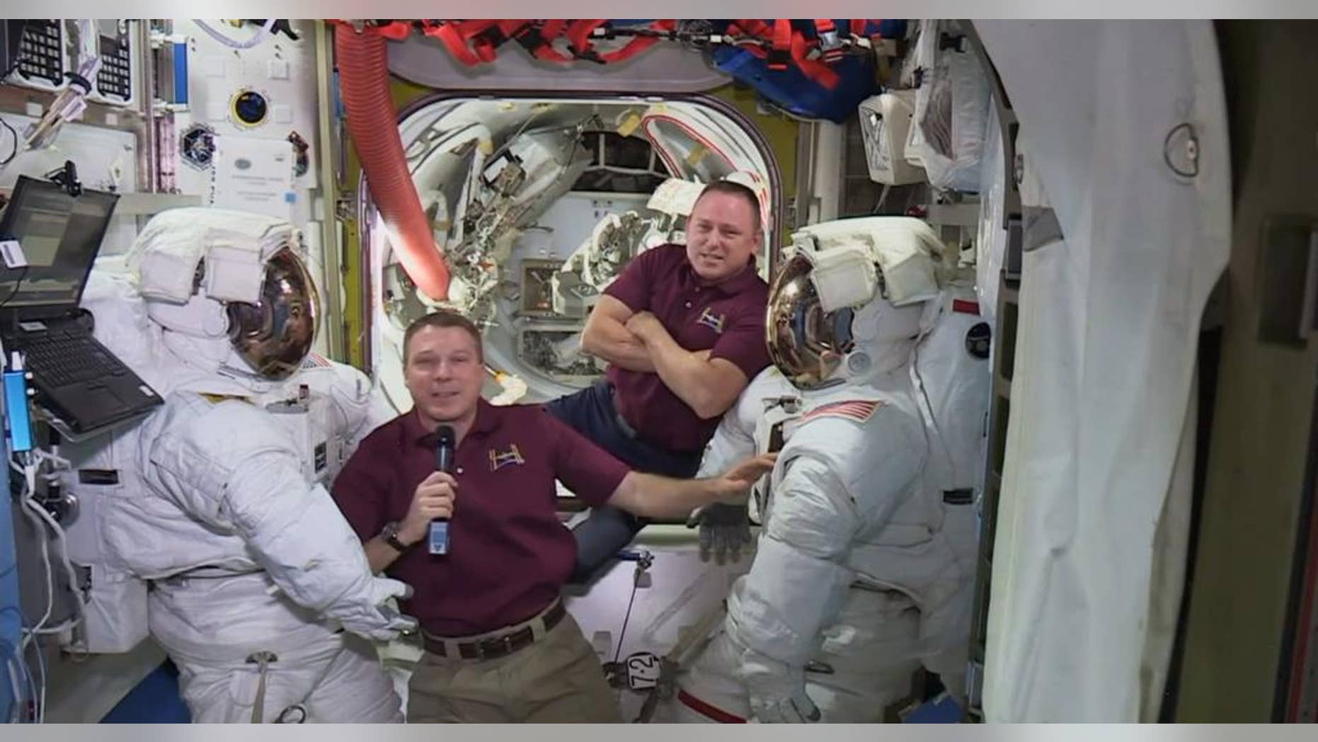 In this image from video made available by NASA, astronauts Terry Virts, left, and Barry Wilmore speak next to their spacesuits during an interview aboard the International Space Station on Wednesday, Feb. 18, 2015. A series of upcoming spacewalks will begin a day late. The first spacewalk by the two U.S. crew members was supposed to occur Friday, 20, 2015. But a day ahead of the maneuver, NASA bumped it to Saturday to complete a spacesuit investigation. (AP Photo/NASA)