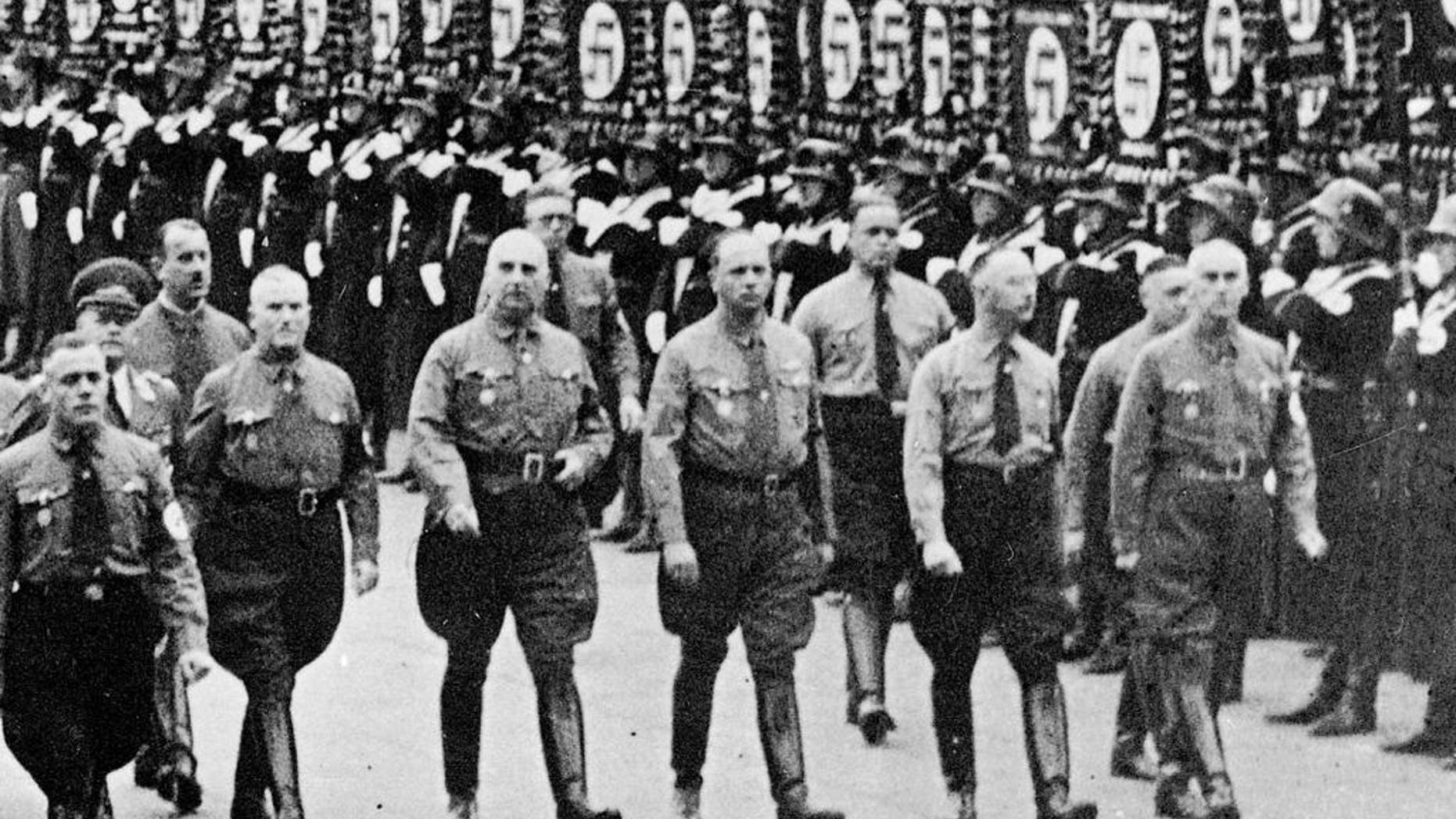 FILE - In this 1938 file photo Heinrich Himmler, second right, chief of secret police and Dr. Wilhelm Frick, right, and other leading members of the Nazi party march along Koenigliche Platz in Munich, southern Germany. A historical commission examining the Nazi links of Germany’s Interior Ministry says more than half of the staffers from 1949 to 1970 had belonged to the Nazi party. In an interim report presented Wednesday, Nov. 4, 2015 the commission said 54 percent of staffers during those years had been former Nazi party members, and many had also been members of the SS or SA. Eight percent had served in the Nazi Interior Ministry, which was run by Wilhelm Frick, who was executed for war crimes, and later SS-chief Heinrich Himmler. (AP Photo/file)