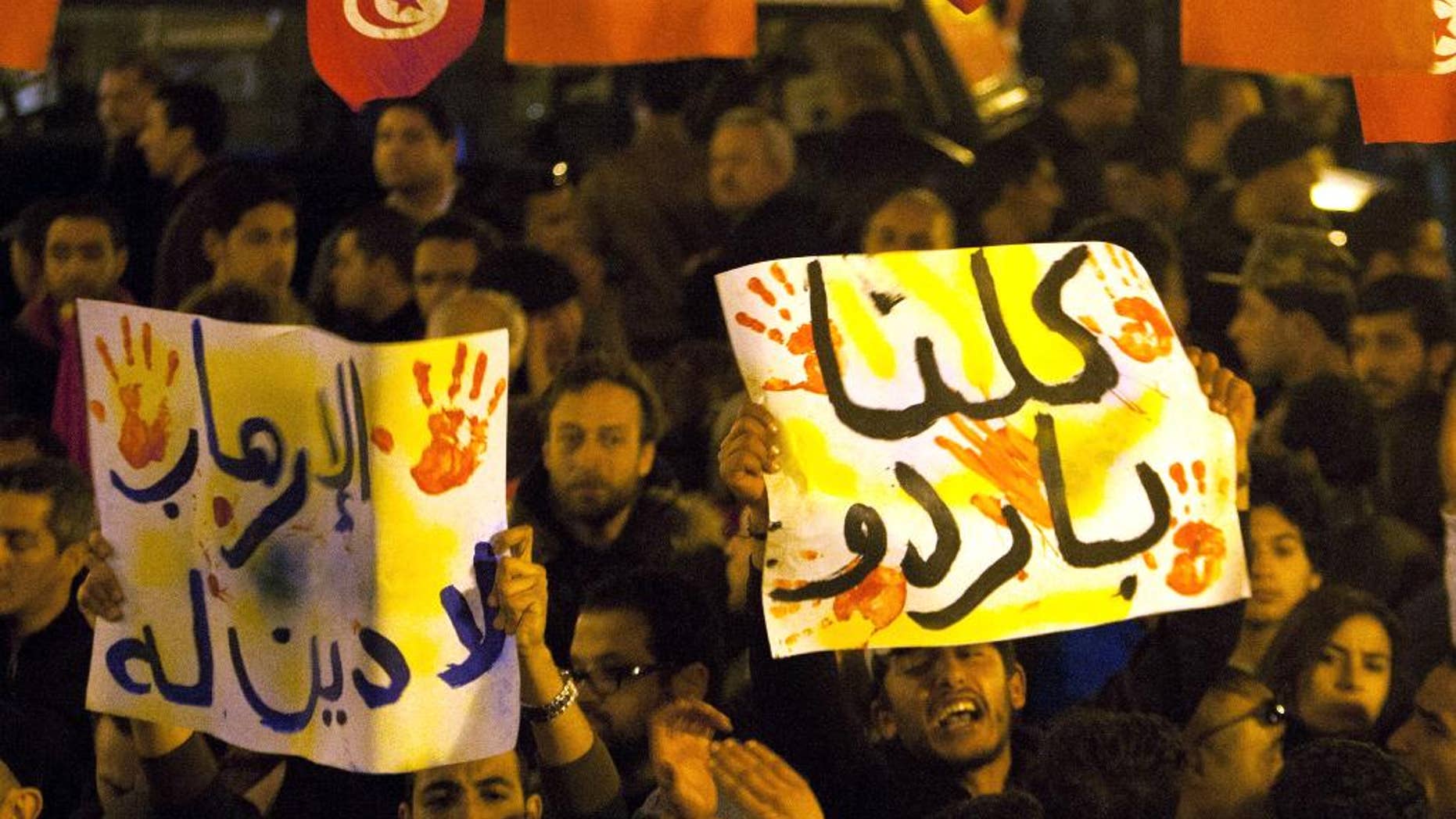 Tunisians gather at Habib Bourguiba avenue to show solidarity with the victims of the attack at a museum in Tunis, Wednesday, March 18, 2015. Gunmen opened fire Wednesday at a major museum in Tunis, killing scores of people, mostly foreigners, in one of the worst attacks in this struggling North African democracy that depends heavily on tourism. Placard reads, "no to terrorists". (AP Photo/Adel Mhamdi)