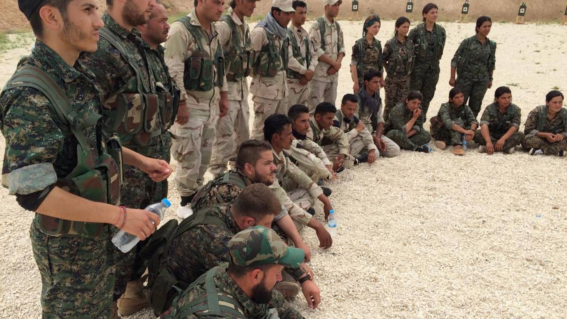 In this photo taken May 21, 2016, members of what the U.S. calls the Syrian Democratic Forces gather after a training session at a firing range in northern Syria. U.S. Gen. Joseph Votel, the head of Central Command, visited the camp to consult with Syrians and talk to US military advisers working with the Syrian fighters. (AP Photo/Robert Burns)