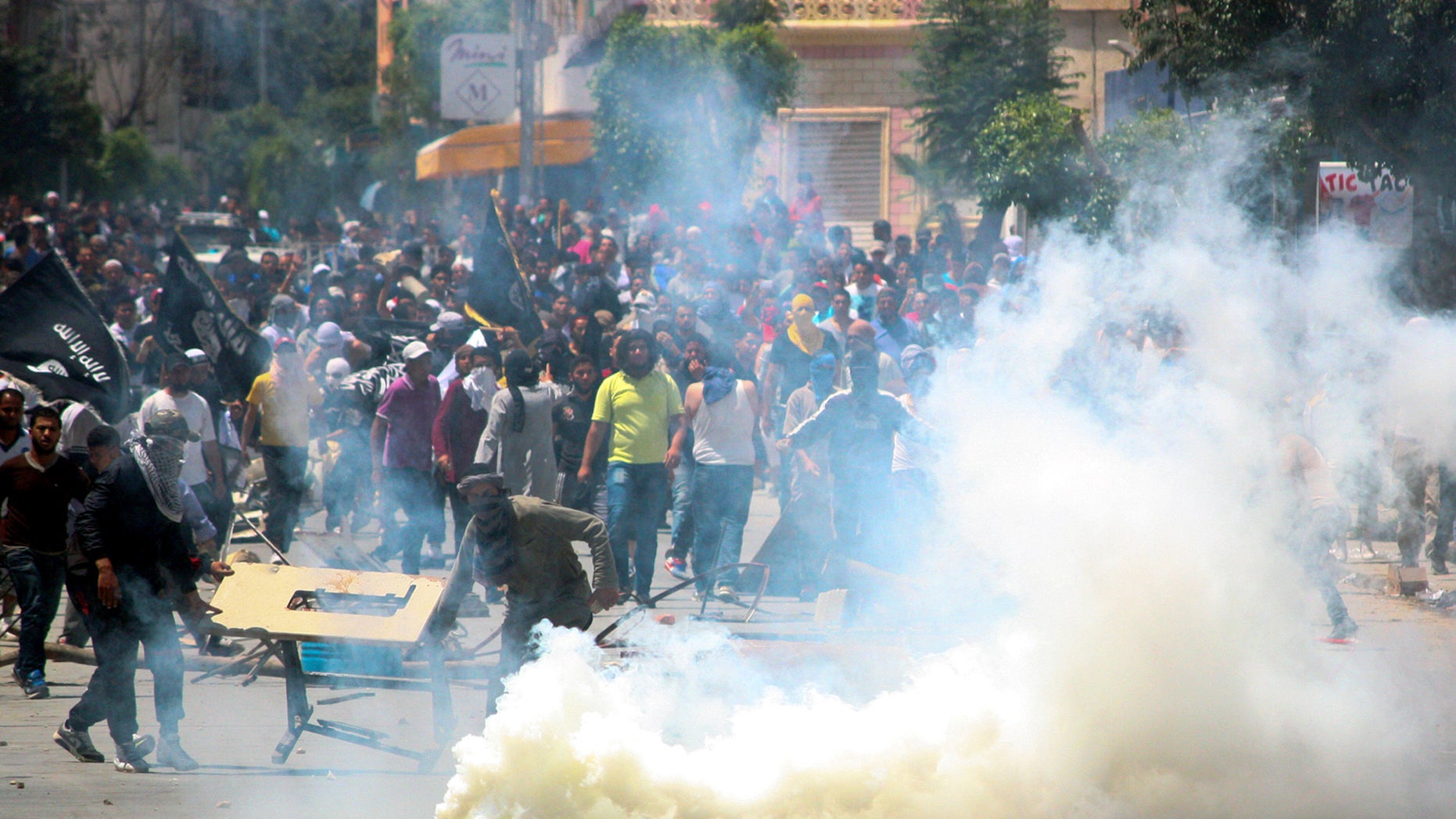 Radical Islamist movement Ansar al-Shariah supporters clash with Tunisian police officers after Tunisia's Interior Ministry on Friday banned their annual conference supposed to be held in Kairouan, in Ettadhamen, near Tunis, Sunday May 19, 2013. Massive numbers of Tunisian police and army surrounded Tunisia's religious center of Kairouan to prevent a conference by a radical Islamist movement that has been implicated in attacks around the country. (AP Photo/Nawfel)