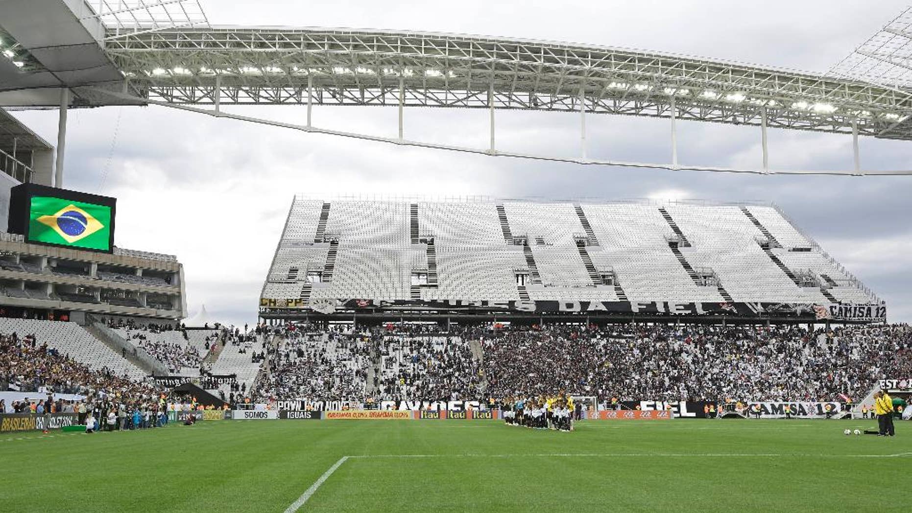 Corinthians's and Botafogo players listen to the national anthem prior to a Brazilian soccer league match at the Itaquerao, the stadium that will host the World Cup opener match between Brazil and Croatia on June 12, in Sao Paulo, Brazil, Sunday, June 1, 2014. (AP Photo/Andre Penner)