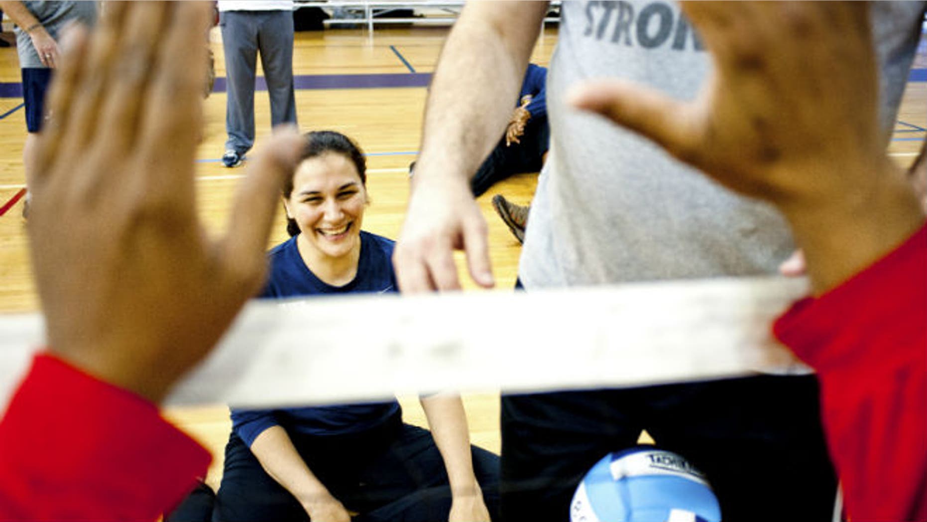 Ensign Laura Root runs through a sitting volleyball drill during an adaptive athletics camp for wounded soldiers at Naval Station Norfolk, Virginia February 8, 2013. REUTERS/Rich-Joseph Facun