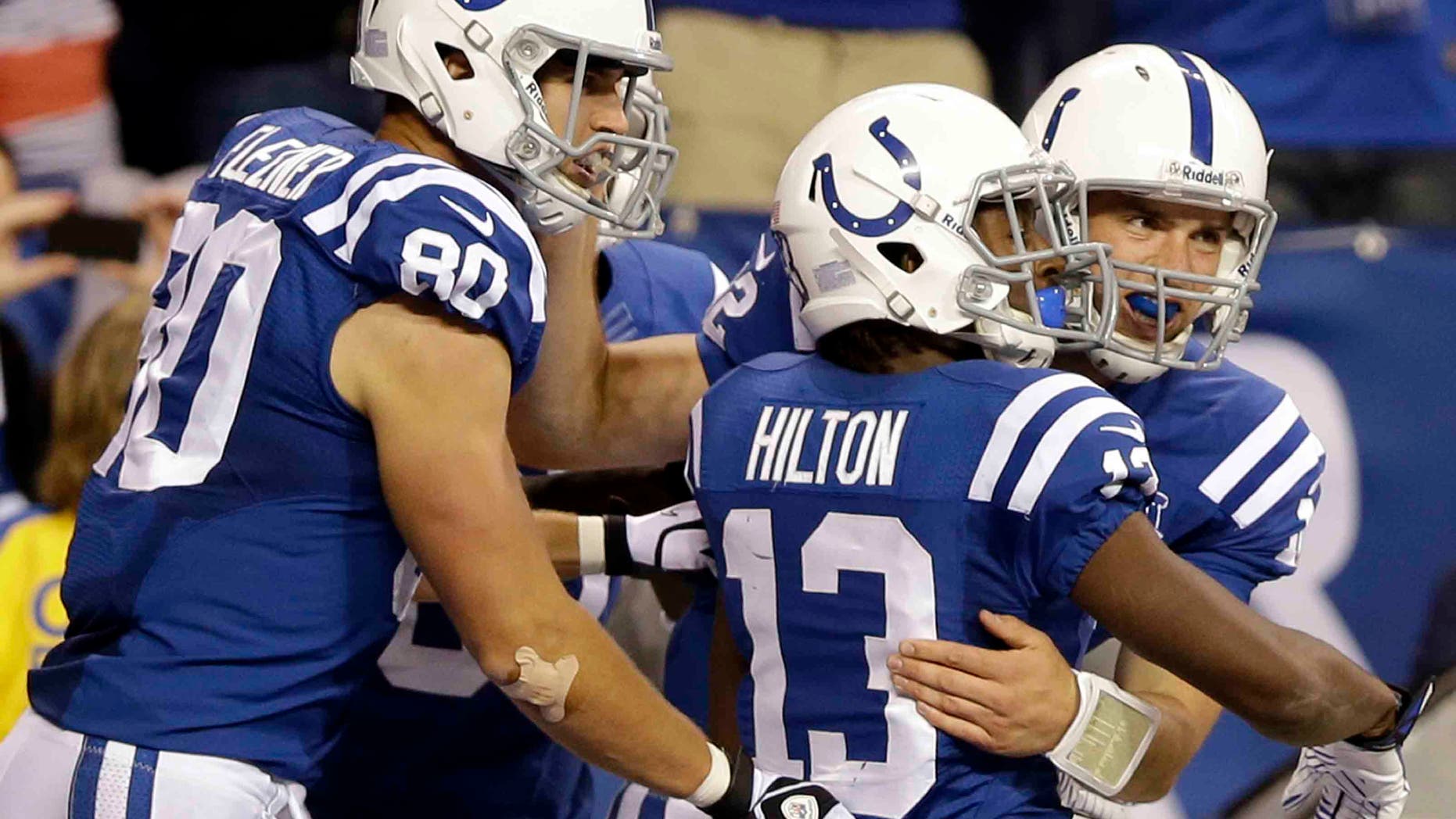 FILE - In this Oct. 20, 2013 file photo, Indianapolis Colts quarterback Andrew Luck celebrates his touchdown with tight end Coby Fleener (80) and wide receiver T.Y. Hilton (13) during the second half of an NFL football game against the Denver Broncos, in Indianapolis. Last season, the Colts overcame the loss of Peyton Manning and the loss of their coach as he battled cancer to make the playoffs. This season, Andrew Luck has already guided Indy to three fourth-quarter wins and the Colts are a remarkable 13-2 in one-possession games over the last two seasons.(AP Photo/Michael Conroy, File)