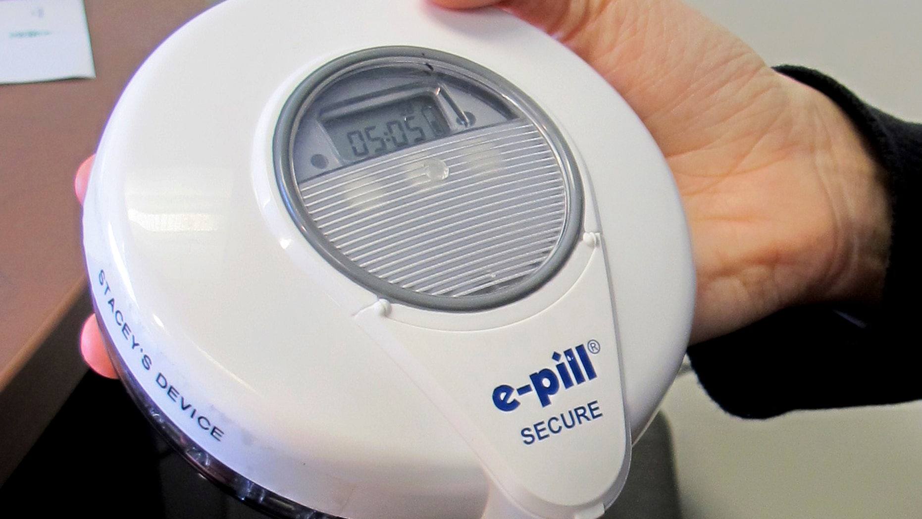University of Vermont Psychologist Stacey Sigmon holds a tamper-proof electronic pill dispenser in her office in Burlington, Vt., Wednesday, Dec. 21, 2016. People hooked on prescription painkillers were able to use the device to take a drug at home to curb cravings and prevent abuse while waiting to get in a treatment program. Use of the device showed dramatic results in helping people who use the system remain free of illicit opioids. (AP Photo/Wilson Ring)