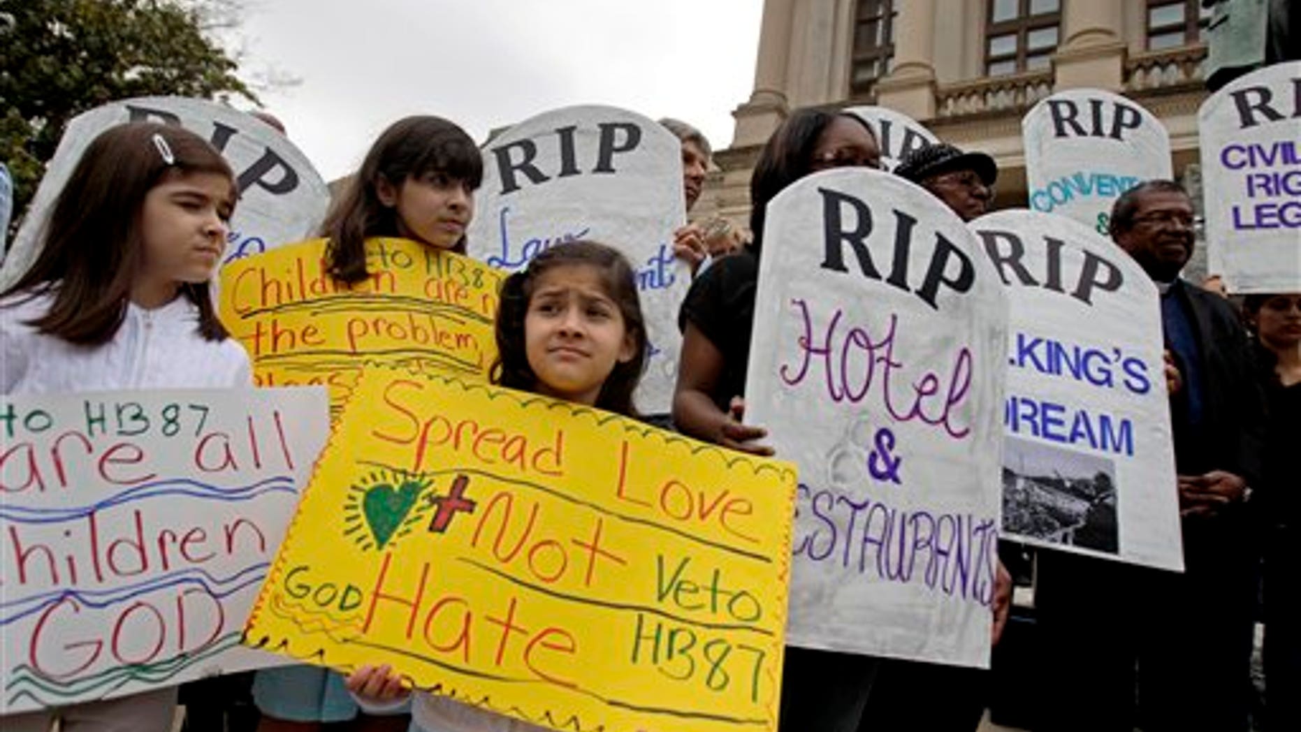 Alexandra Leon, 6, of Atlanta, center, attends a rally against a proposed Arizona-style immigration bill Monday, April 11, 2011 outside the State Capitol in Atlanta. Activist groups delivered a petition Monday Gov. Nathan Deal to urge him to veto the bill that aims to crack down on illegal immigration. (AP Photo/David Goldman)