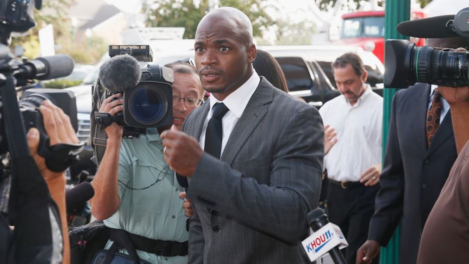 CONROE, TX - OCTOBER 08: NFL player Adrian Peterson of the Minnesota Vikings walks to a court appearance at the Montgomery County municipal building on October 8, 2014 in Conroe, Texas. Peterson did not enter a plea, and after about an hour in the courtroom the hearing was reset. A tentative trial date was set for Dec. 1. Petersen is facing charges of reckless or negligent injury to a child. (Photo by Scott Halleran/Getty Images)
