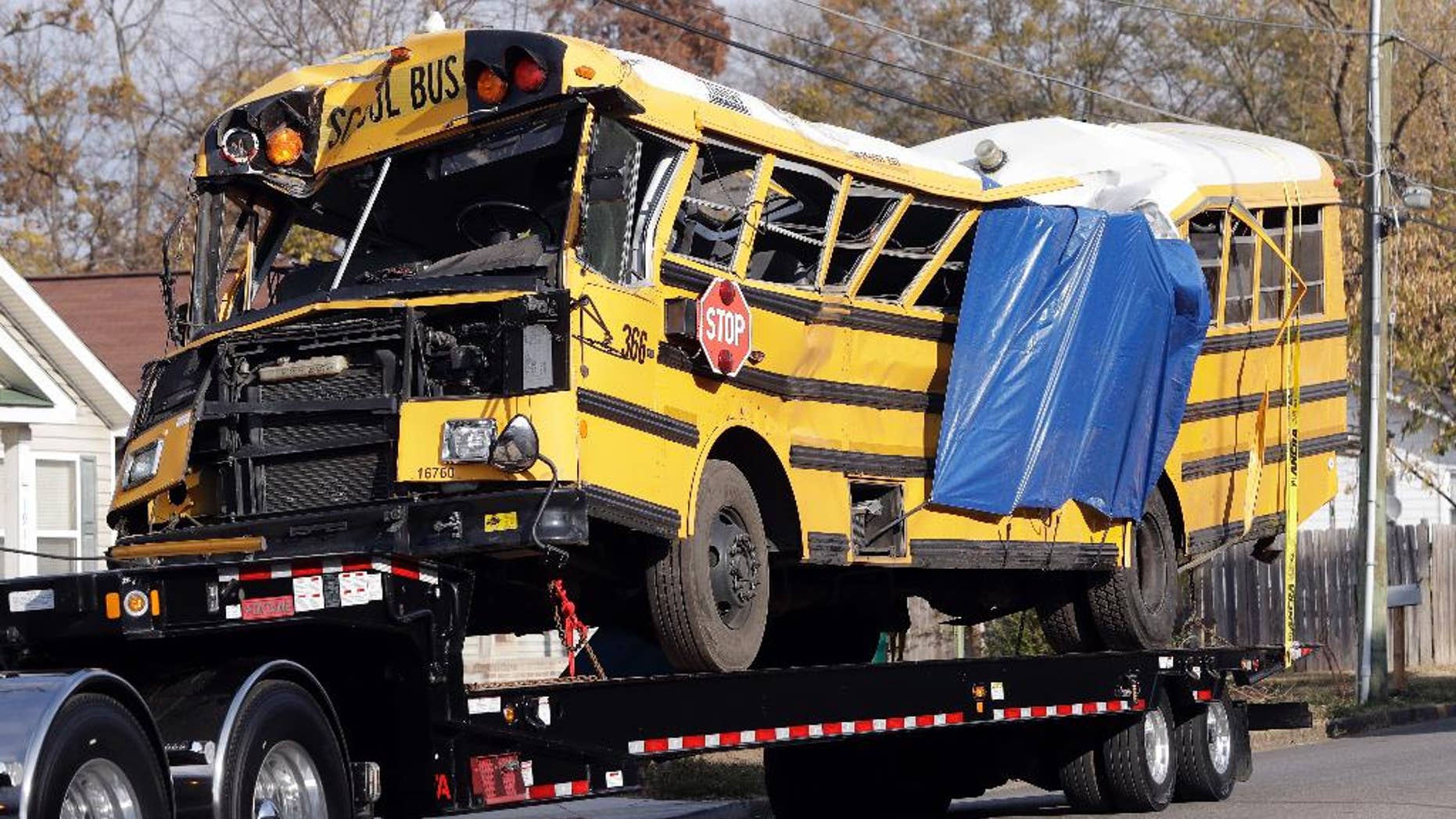 FILE - In a Tuesday, Nov. 22, 2016 file photo, a school bus is carried away, in Chattanooga, Tenn, from the site where it crashed on Monday. Attorney Amanda Dunn says she anticipates bus driver Johnthony Walker will plead not guilty if a grand jury indicts him. He's charged with five counts of vehicular homicide. Police say another count will be added. (AP Photo/Mark Humphrey, File)