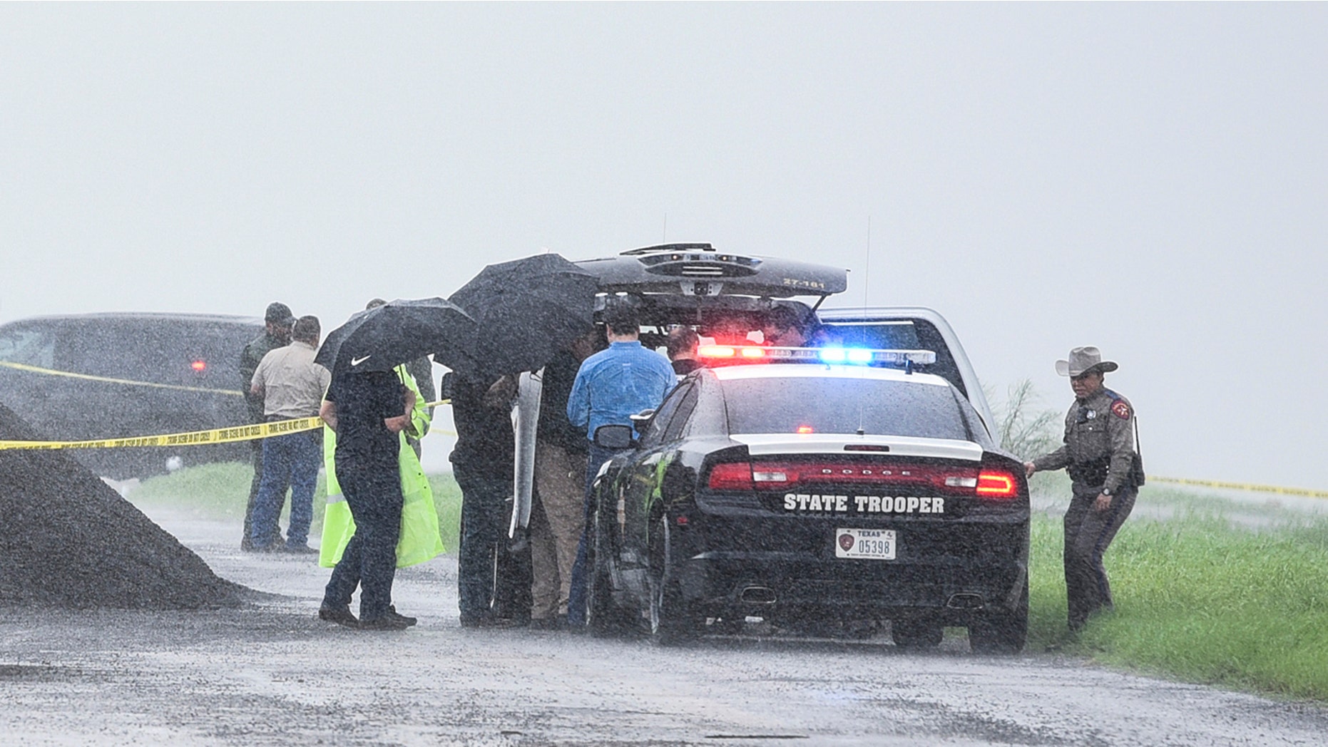 Law enforcement officers gather near the scene where the body of a woman was found near Interstate 35 north of Laredo, Texas on Saturday, Sept. 15, 2018.