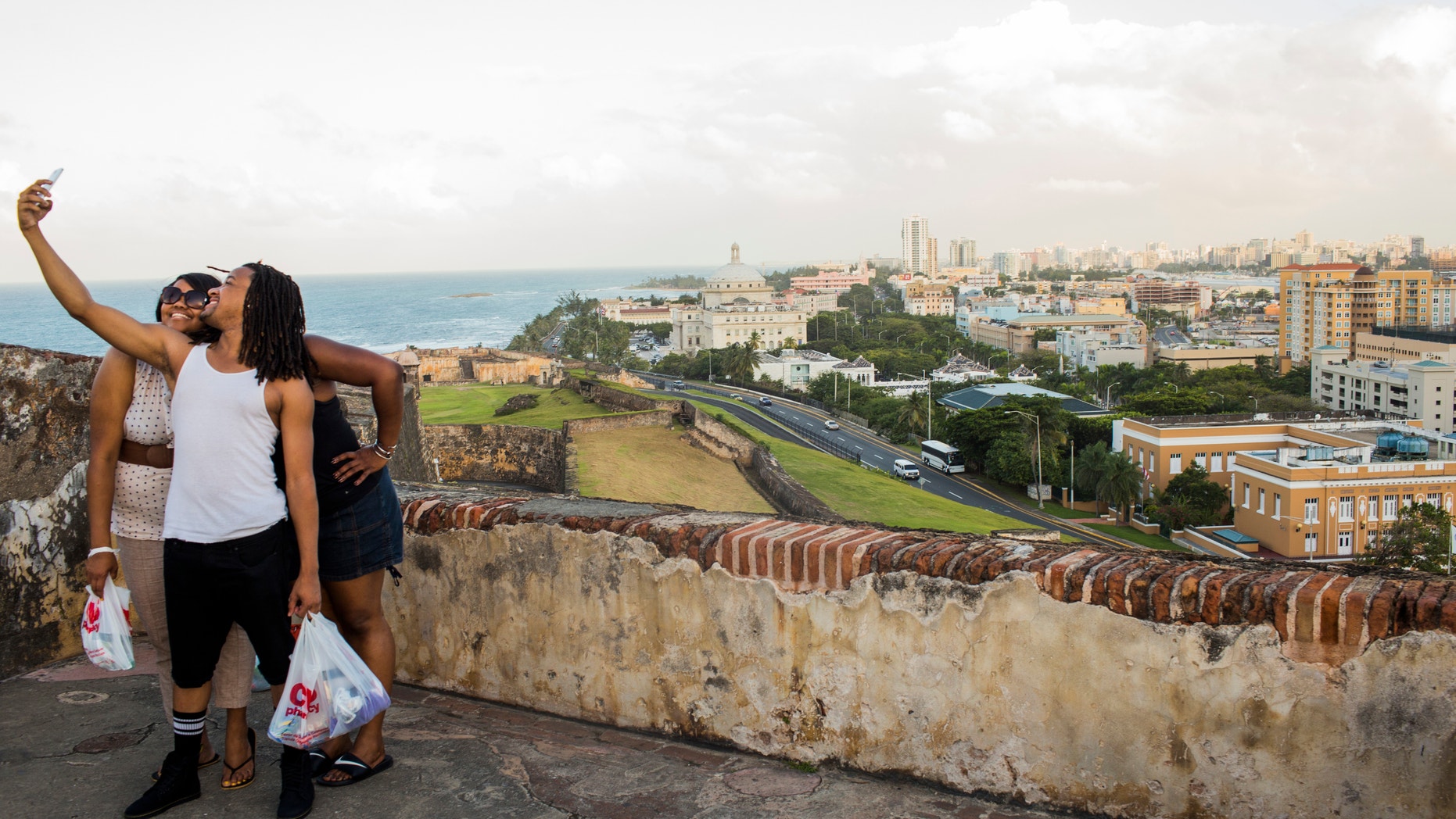 Friends pose for a photo in front of Old San Juan, the center for Puerto Rican tourism, on November 12, 2013.