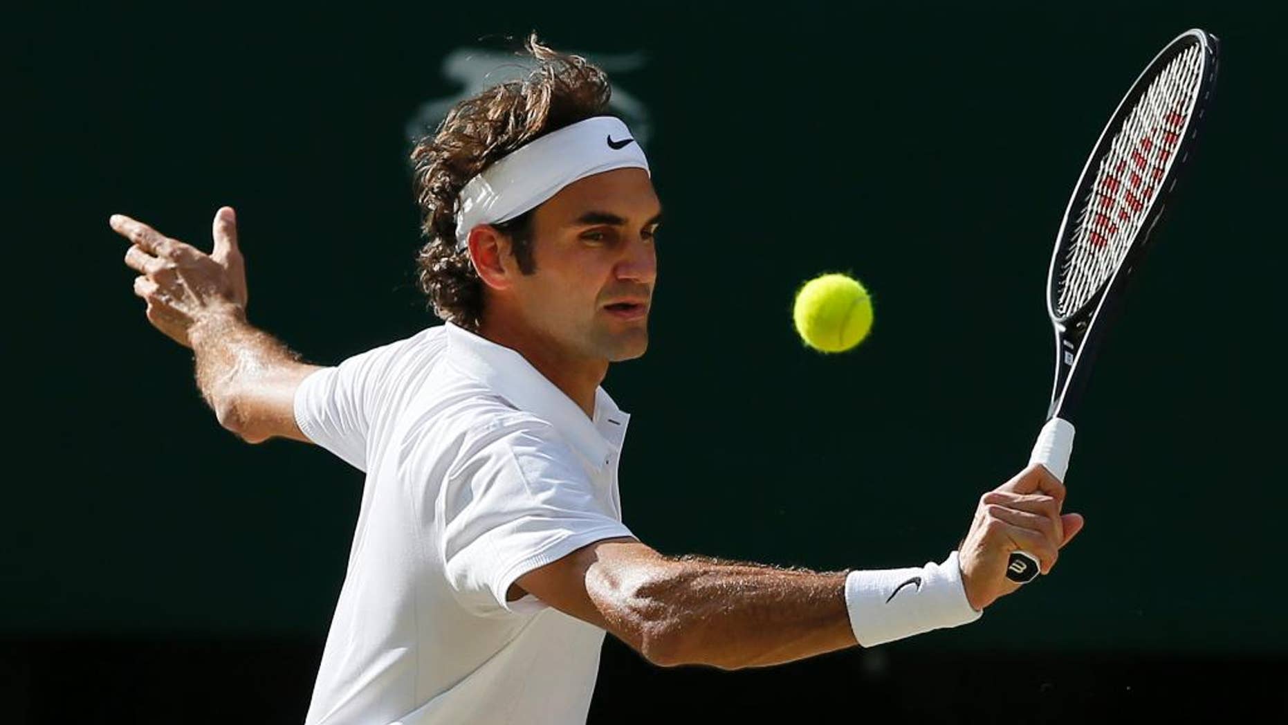 Roger Federer of Switzerland plays a return to Milos Raonic of Canada during their men’s singles semifinal match at the All England Lawn Tennis Championships in Wimbledon, London, Friday, July 4, 2014. (AP Photo/Ben Curtis)