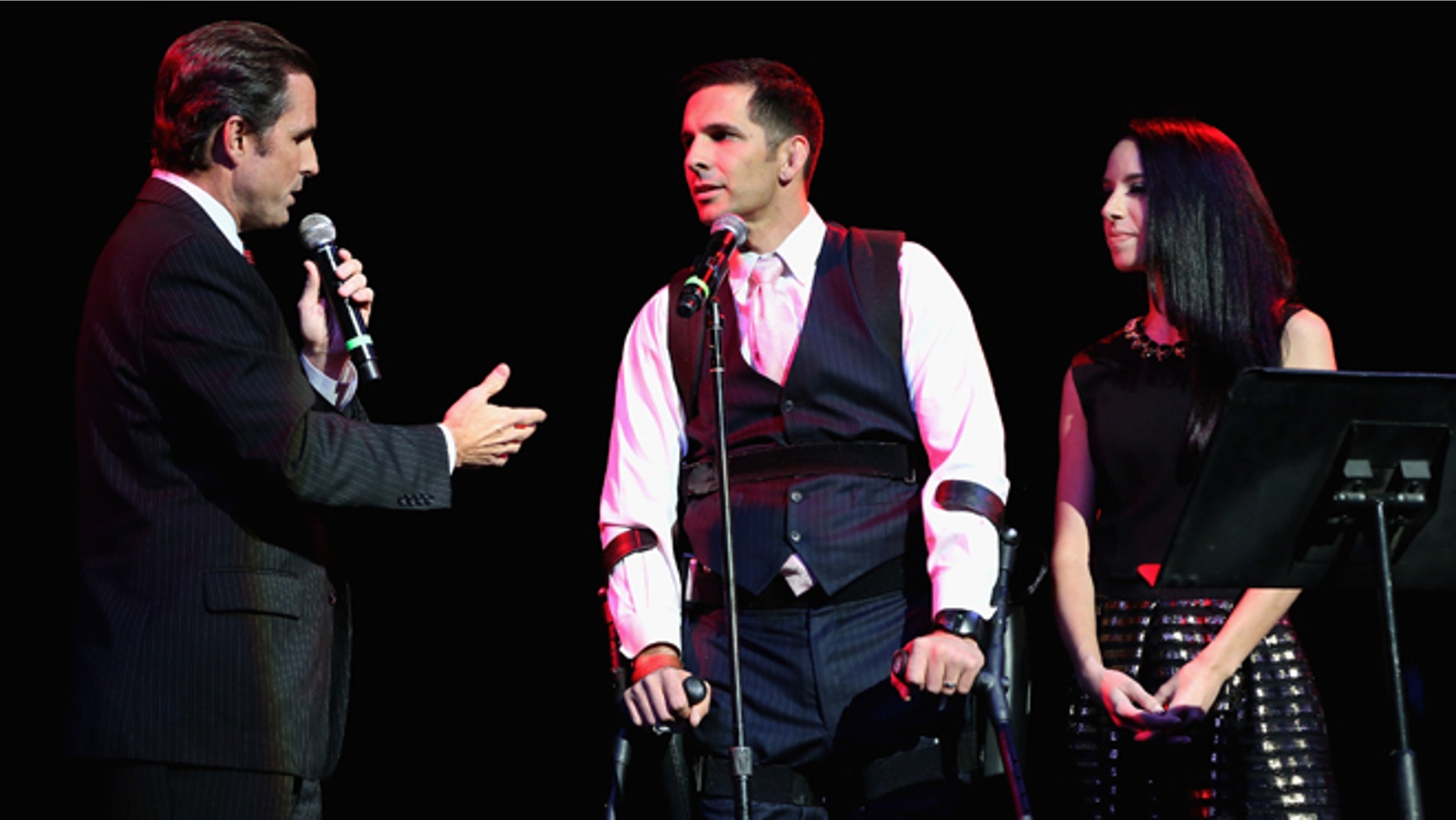 NEW YORK, NY - NOVEMBER 05: (L-R) Bob Woodruff, Derek Herrera, Captain, US Marine Corps, Active and Maura Herrera walks onstage at 2014 Stand Up For Heroes at Madison Square Garden at Madison Square Garden on November 5, 2014 in New York City. (Photo by Monica Schipper/Getty Images for New York Comedy Festival)